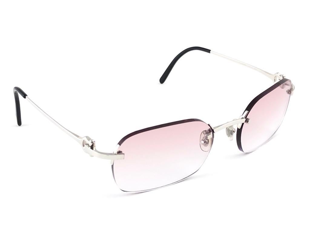 New 1990 Cartier platinum unique rimless sunglasses with light rose gradient  (uv protection) lenses. Frame with the front and sides in platine. All hallmarks. 

Cartier signs on the black ear paddles. 

Please notice this item its nearly 30 years