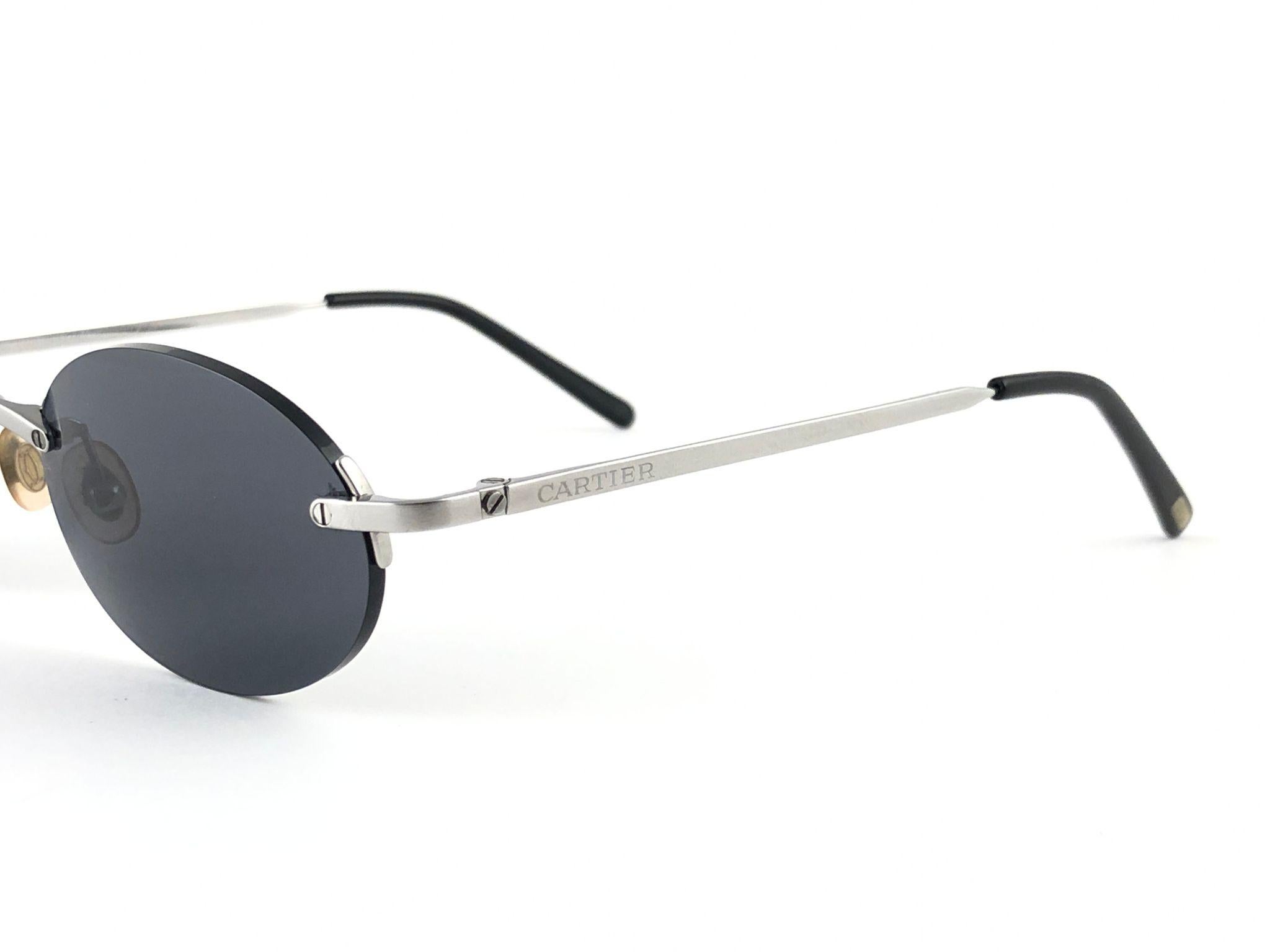 Neu Cartier Salisbury einzigartige randlose Sonnenbrille mit dunkelgrau  (UV-Schutz) Linsen.  Rahmen mit Front und Seiten aus Titan. Alle Markenzeichen. Cartier-Silberzeichen auf den Ohrmuscheln.  Sie sind wie ein Paar Juwelen auf der Nase.  Schönes