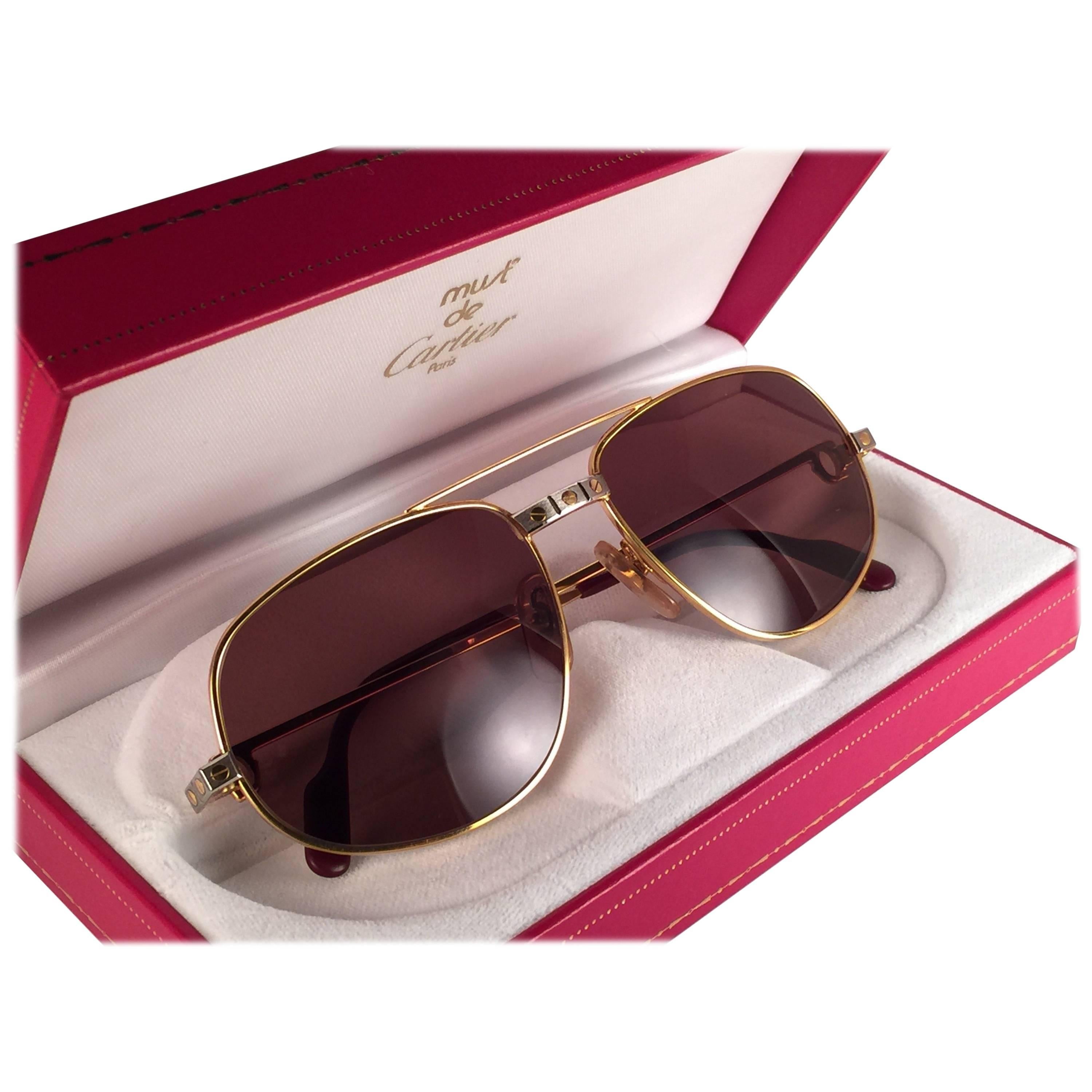 Gafas de sol vintage Cartier Romance Santos con lentes marrones macizas (protección uv).  El marco es con el anverso y los laterales en oro amarillo y blanco. Todos los sellos distintivos. Esmalte rojo con signos Cartier dorados en las palas de las