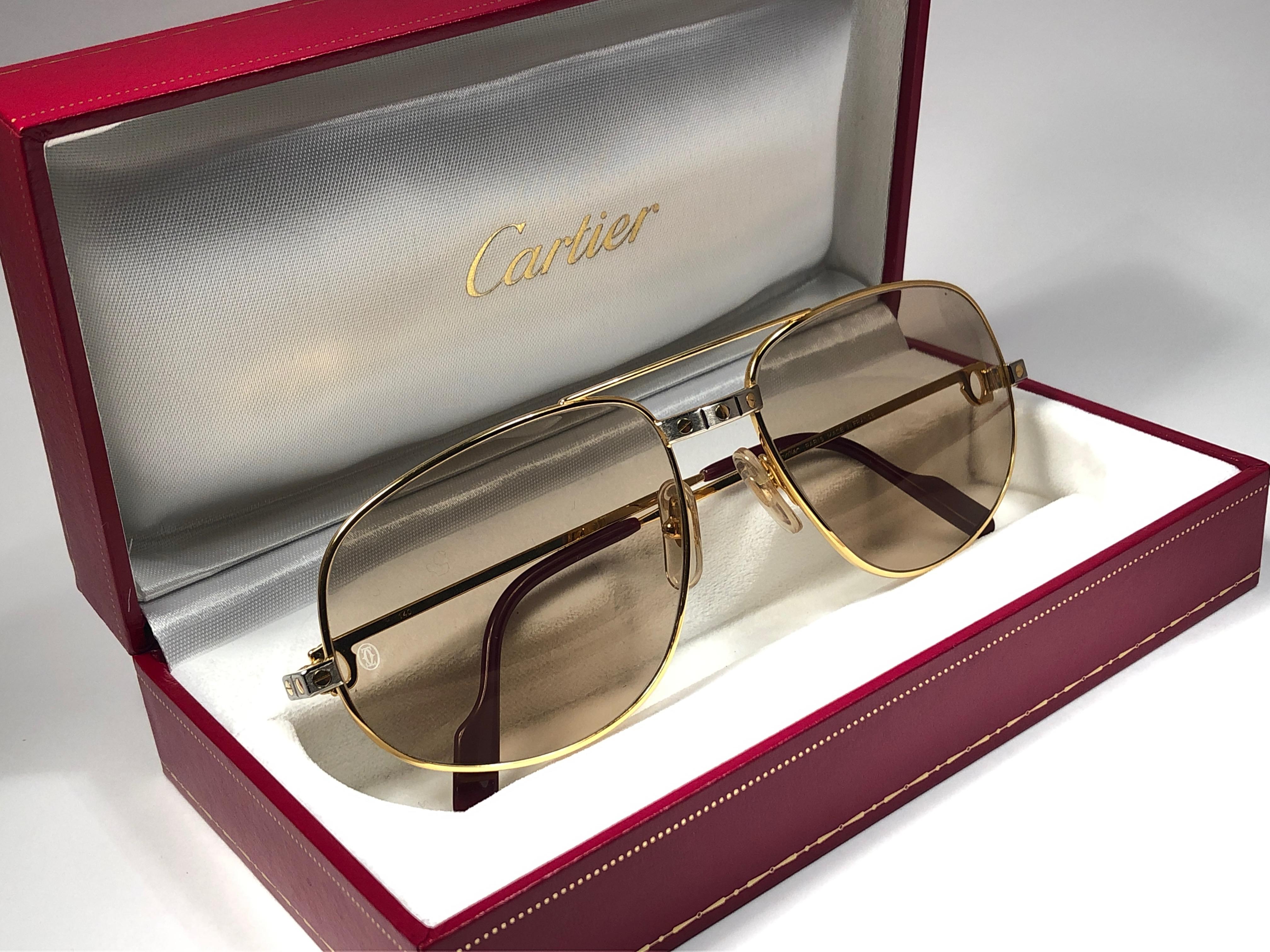 Vintage Cartier Romance Santos sunglasses with the light brown Cartier (uv protection) lenses.  Frame is with the front and sides in yellow and white gold. All hallmarks. Red enamel with Cartier gold signs on the ear paddles. Both arms sport the C