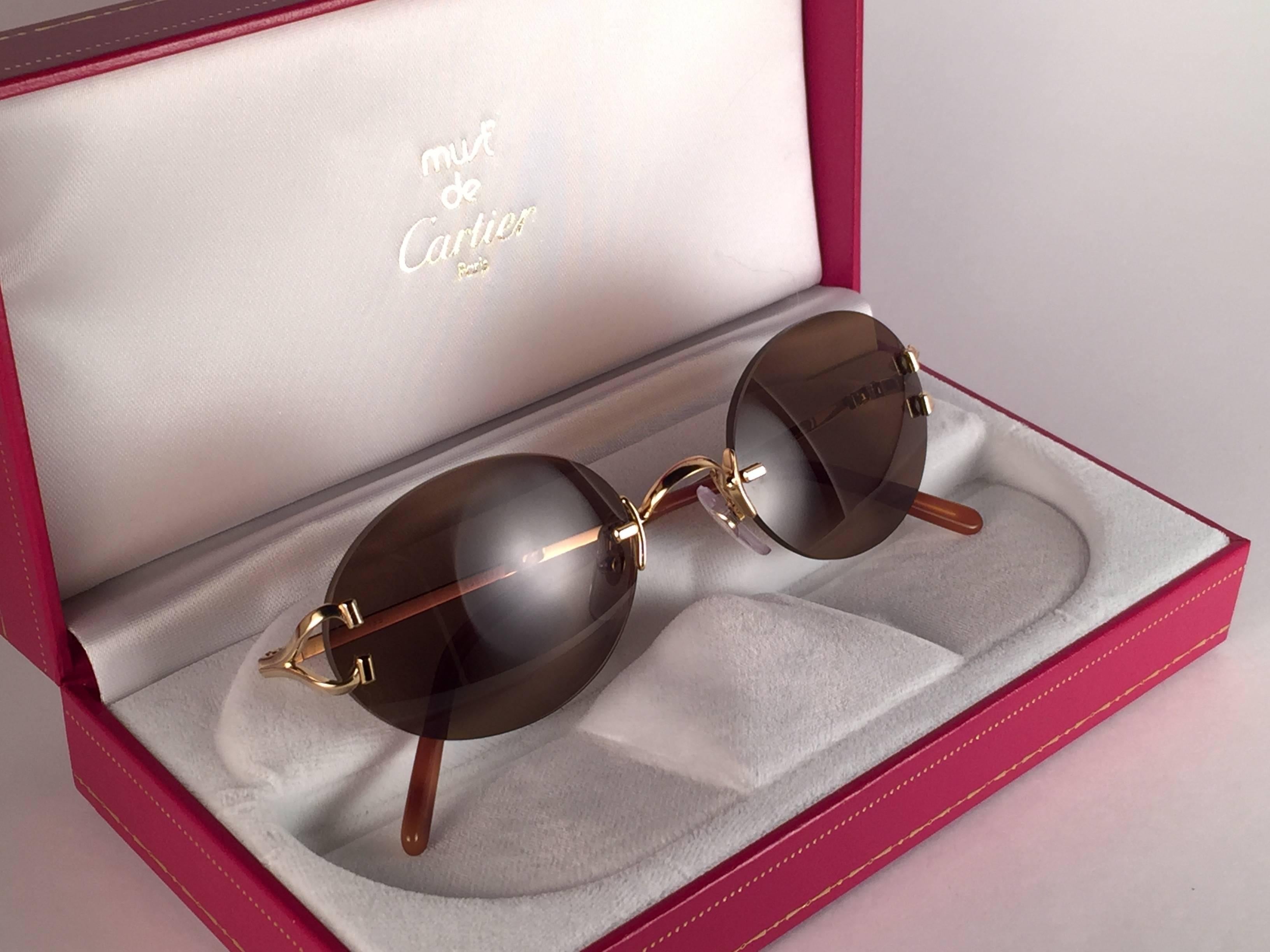 New 1990 Cartier Scala unique rimless sunglasses with brown  (uv protection) lenses. Frame with the front and sides in gold. All hallmarks. Cartier gold signs on the honey ear paddles. These are like a pair of jewels on your nose. Beautiful design