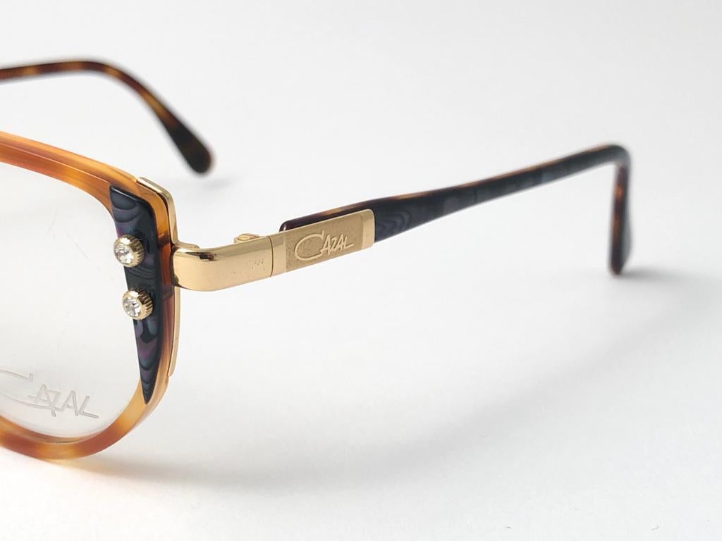 New Vintage Cazal 332 Tortoise with Gold & Marbled details frame. Perfect for reading spectacles.  This item may show minor sign of wear due to almost 30 years of storage.
Made in Germany.


Front   14  cms
Lense Hight    4  cms
Lense Width    5.1 