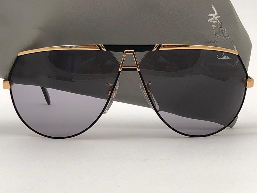 New Vintage Cazal collectors item gold and black frame. 

Grey lenses with light wear due to storage.

Original case.

Made in Germany.

MEASUREMENTS 

FRONT : 15 CMS

LENS HEIGHT : 5.5 CMS

LENS WIDTH : 6.5 CMS 