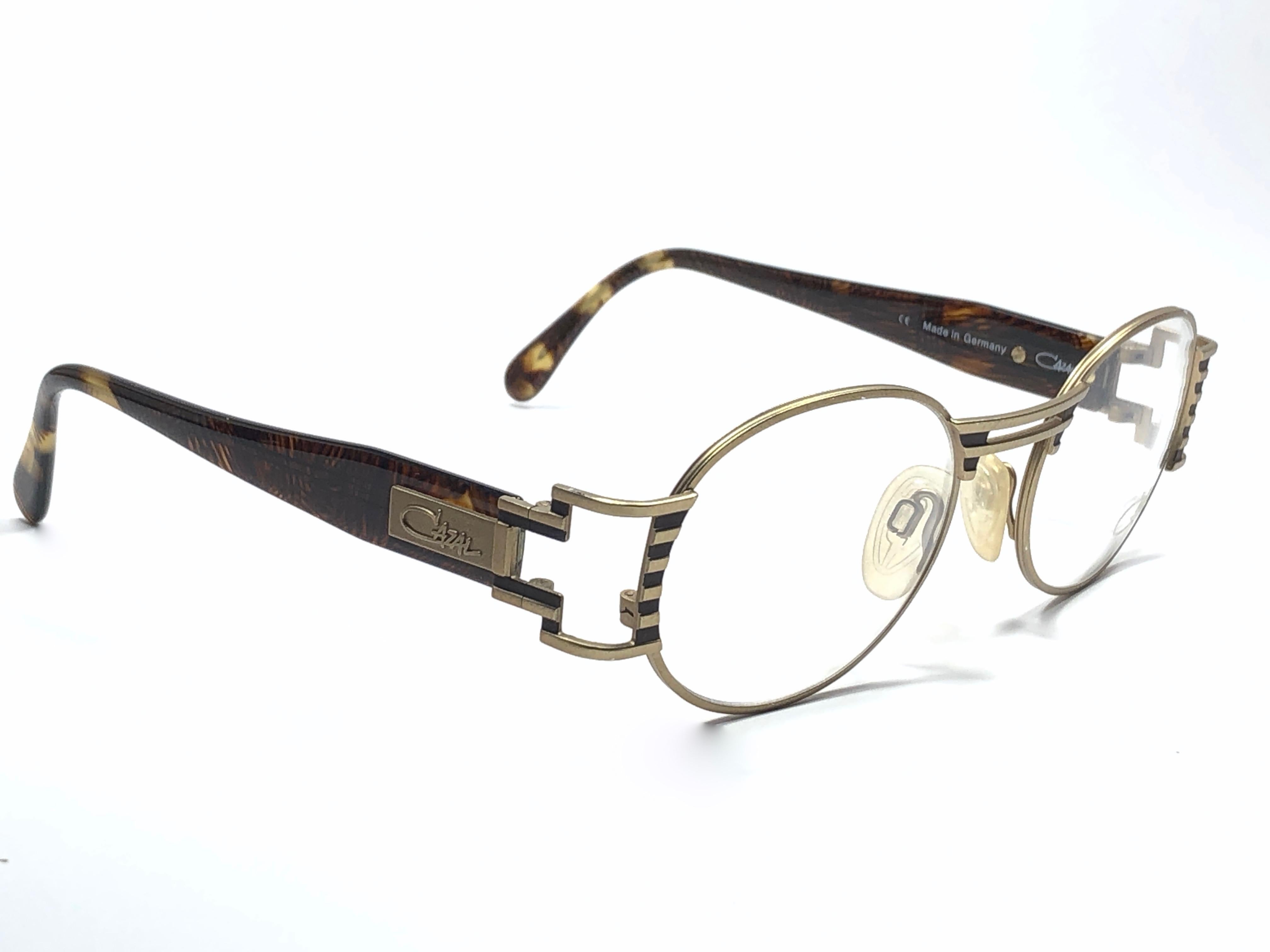 New Vintage Cazal 976 Silver Oval With Black Details Frame. 

Comes With Its Original Cazal Case. This Item May Show Minor Sign Of Wear Due To Storage.

Made In West Germany.

Front : 14 Cms 
Lens Height : 4 Cms 
Lens Width : 5.2 Cms 
Temples : 12