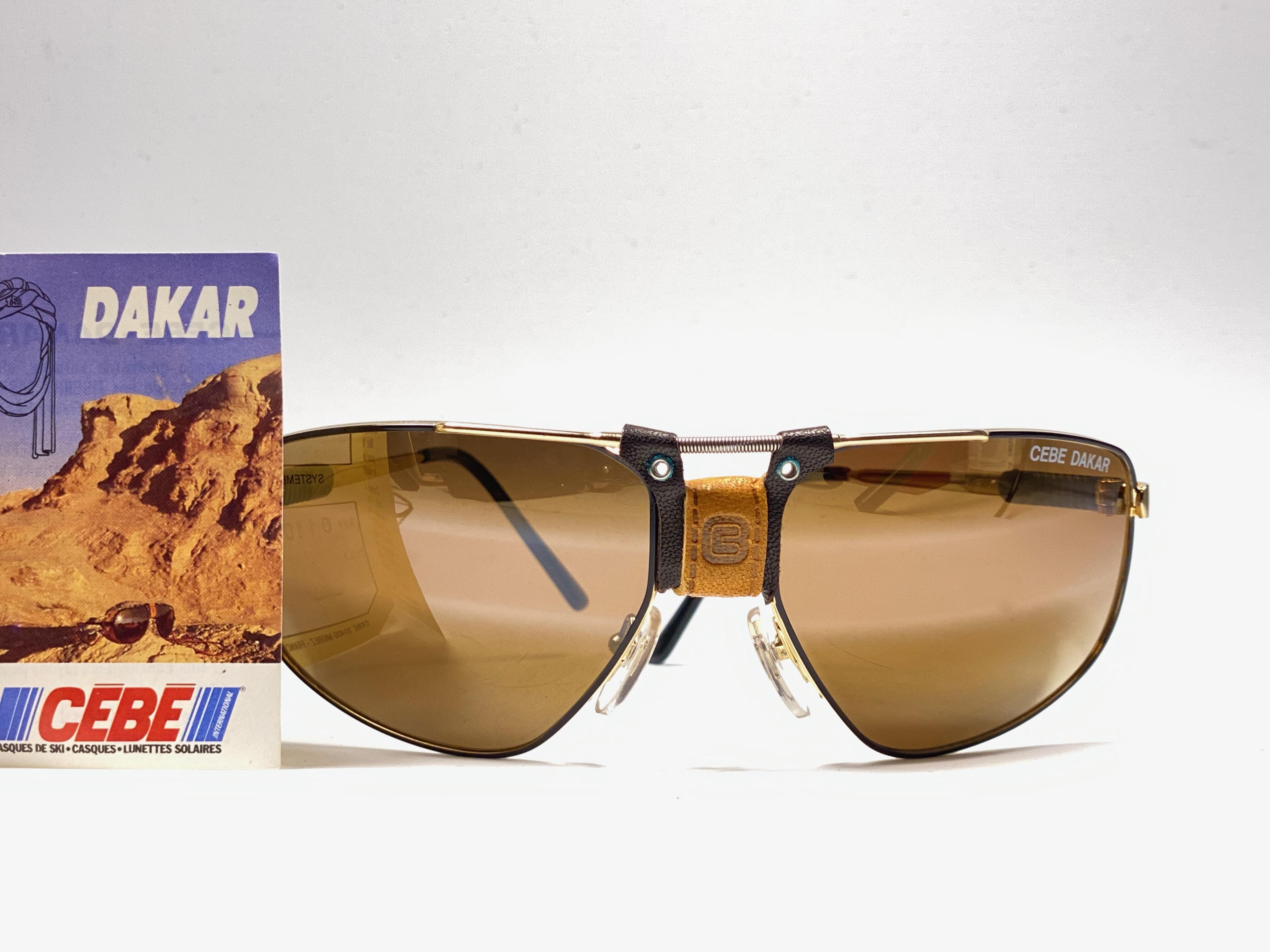 New Vintage Cebe Dakar gold awith leather accents on nose bridge and removable cord sunglasses. From the very same series as the ones worn by the great Miles Davis.

Sturdy and cool frame sporting a pair of gold lenses. 

Never worn or displayed.