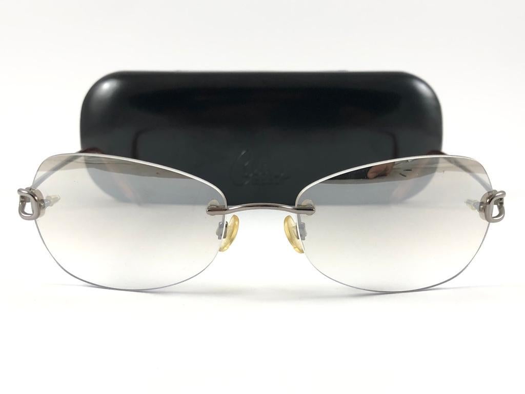 Vintage Celin Dion  Rimless Metallic Grey Frame Holding a pair of Gradient Smoky Grey Lenses 
New, Never worn.
It May Show So Minor Sign Of Wear Due To more Than 20 Years Of Storage.



Front.                                       14 cms
Lens Hight 