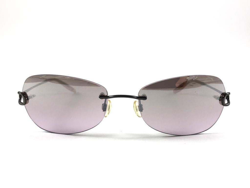 Vintage Celin Dion  Rimless Metallic Grey Frame Holding a pair of Gradient Smoky Purple Lenses 
New, Never worn.
It May Show So Minor Sign Of Wear Due To more Than 20 Years Of Storage.



Front.                                       14 cms
Lens