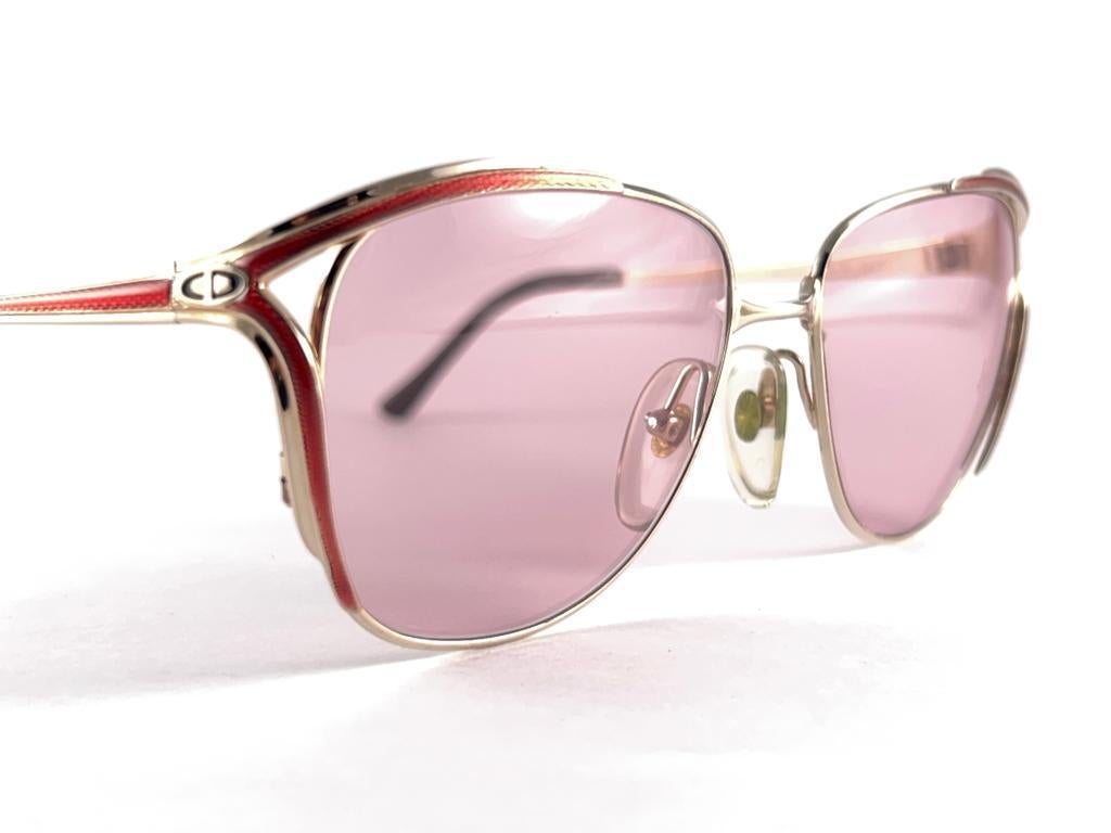 
New Vintage Christian Dior Metallic Gold & Red  Frame Holding A Pair Of Light Pink Lenses 
A Seldom And Rare Piece
New, Never Worn Or Displayed, It May Show Minor Sign Of Wear Due To Storage


 Made In Austria



Front                              