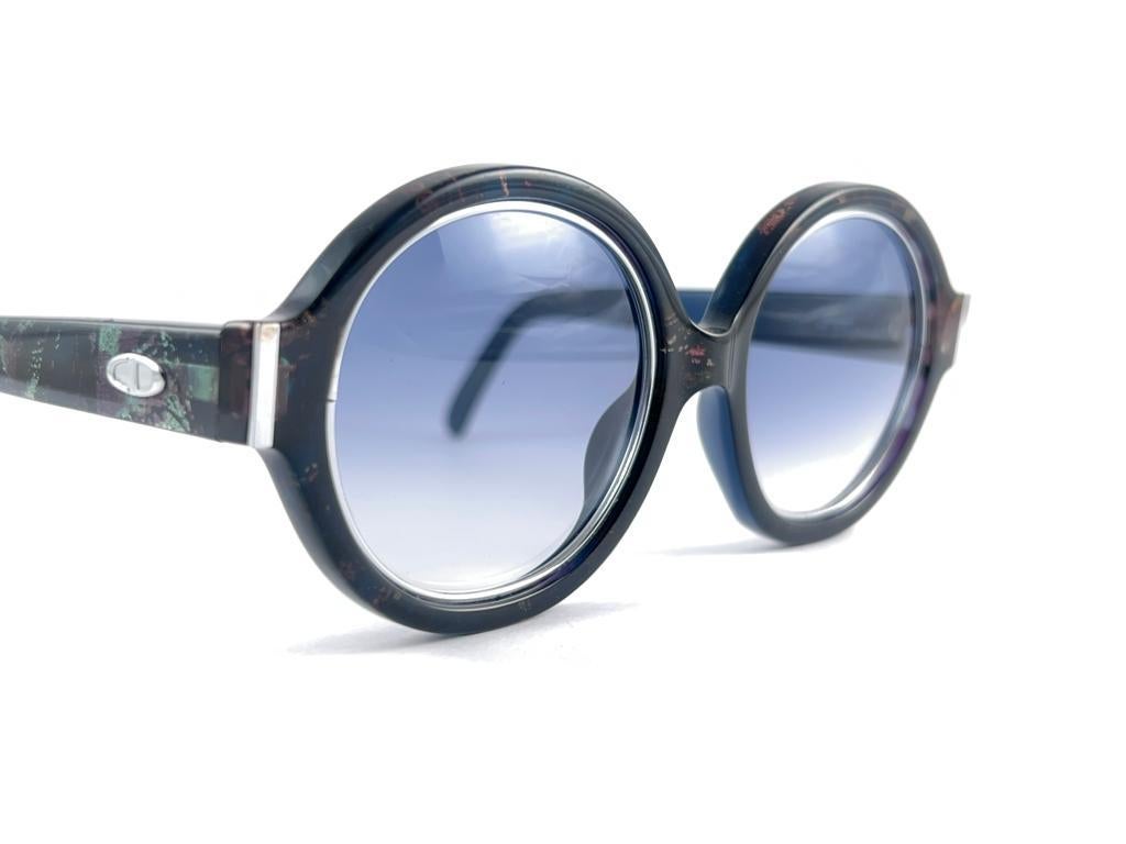 New Vintage Christian Dior 2446 50 Translucent blue mosaic with silver inserts frame sporting spotless magenta gradient lenses.  Produced and design in 1970's.
A collector’s piece!
New, never worn or displayed


Made in Germany



Front             