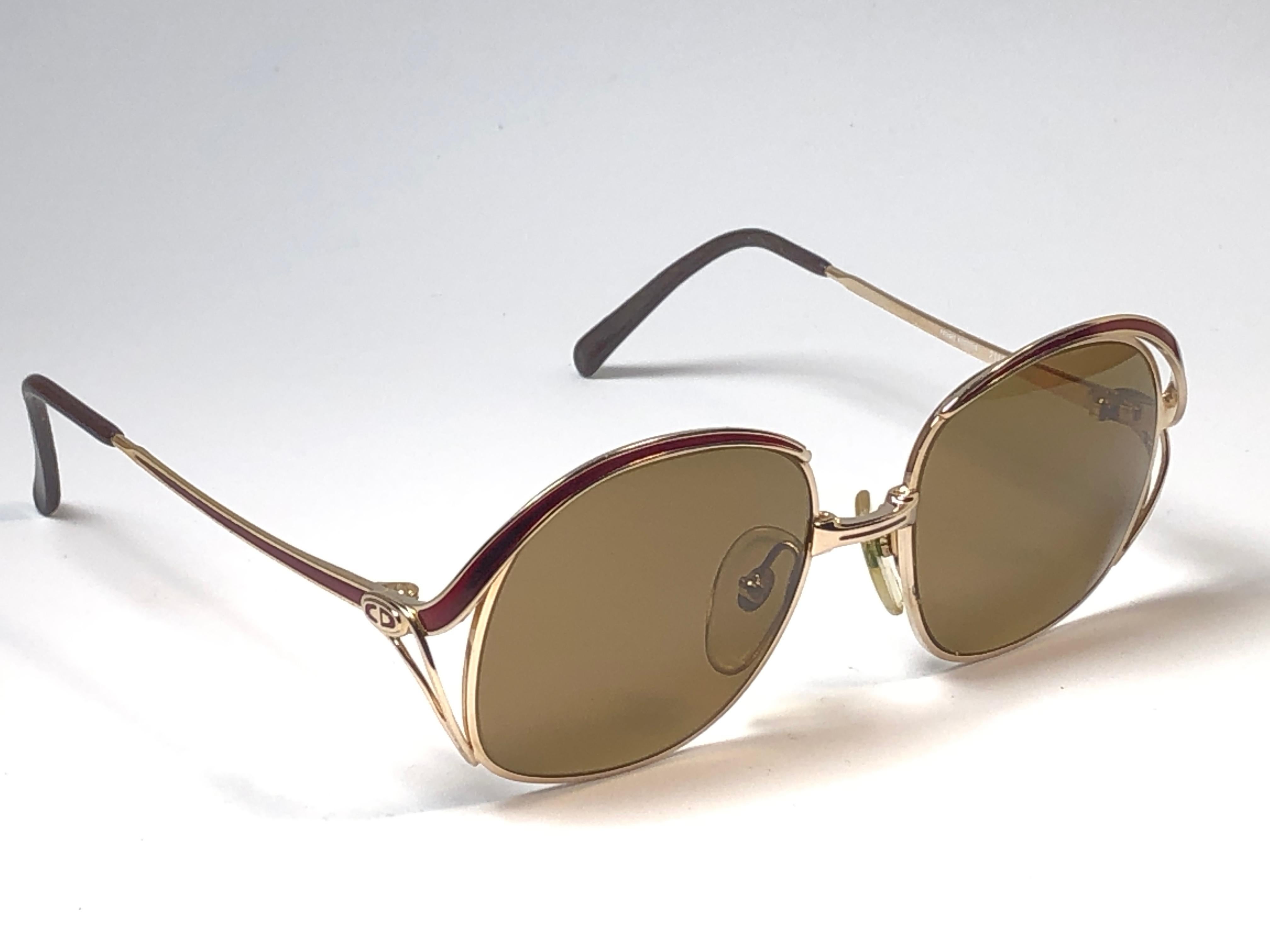 New vintage Christian Dior sunglasses. Burgundy enamel details over a gold frame.

Grey lenses.

Comes with it original CD sleeve.

New, never worn or displayed this item may show light sign of wear due to storage.

Made in Austria
