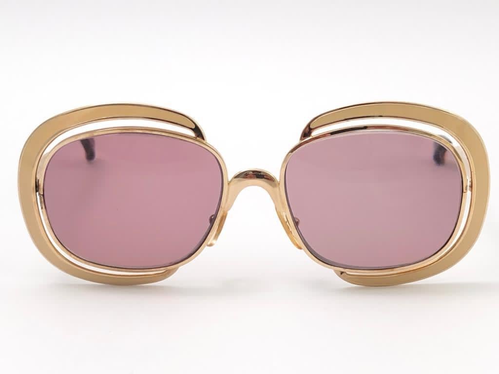 New vintage Christian Dior sunglasses. 
Beige enamel details over a gold frame.

Mauve lenses lenses.

New, never worn or displayed this item may show light sign of wear due to storage.

Made in Austria

FRONT  14 CMS
LENS HEIGHT 4.3 CMS
LENS WIDTH