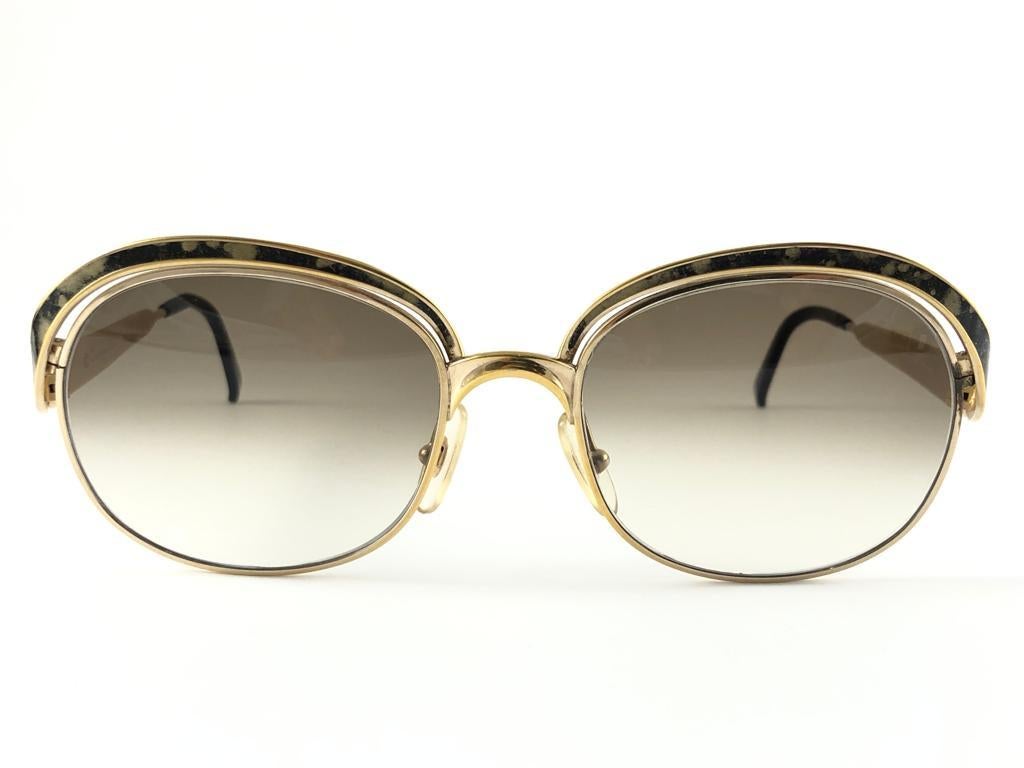 New vintage Christian Dior sunglasses. 
Mosaic enamel details over a gold frame.

Brown gradient lenses.

New, never worn or displayed this item may show light sign of wear due to storage.

Made in Austria

FRONT  14 CMS
LENS HEIGHT 4.5 CMS
LENS