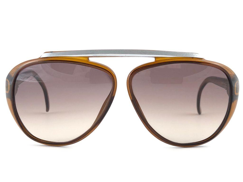 New Vintage Christian Dior 2059 10 Sunglasses oversized translucent amber aviator with spotless lenses 1970’s made by Optyl. 

Manufactured in Austria
 
MEASUREMENTS : 

FRONT : 15 CMS

LENS HEIGHT : 5.2 CMS

LENS WIDTH : 6 CMS


