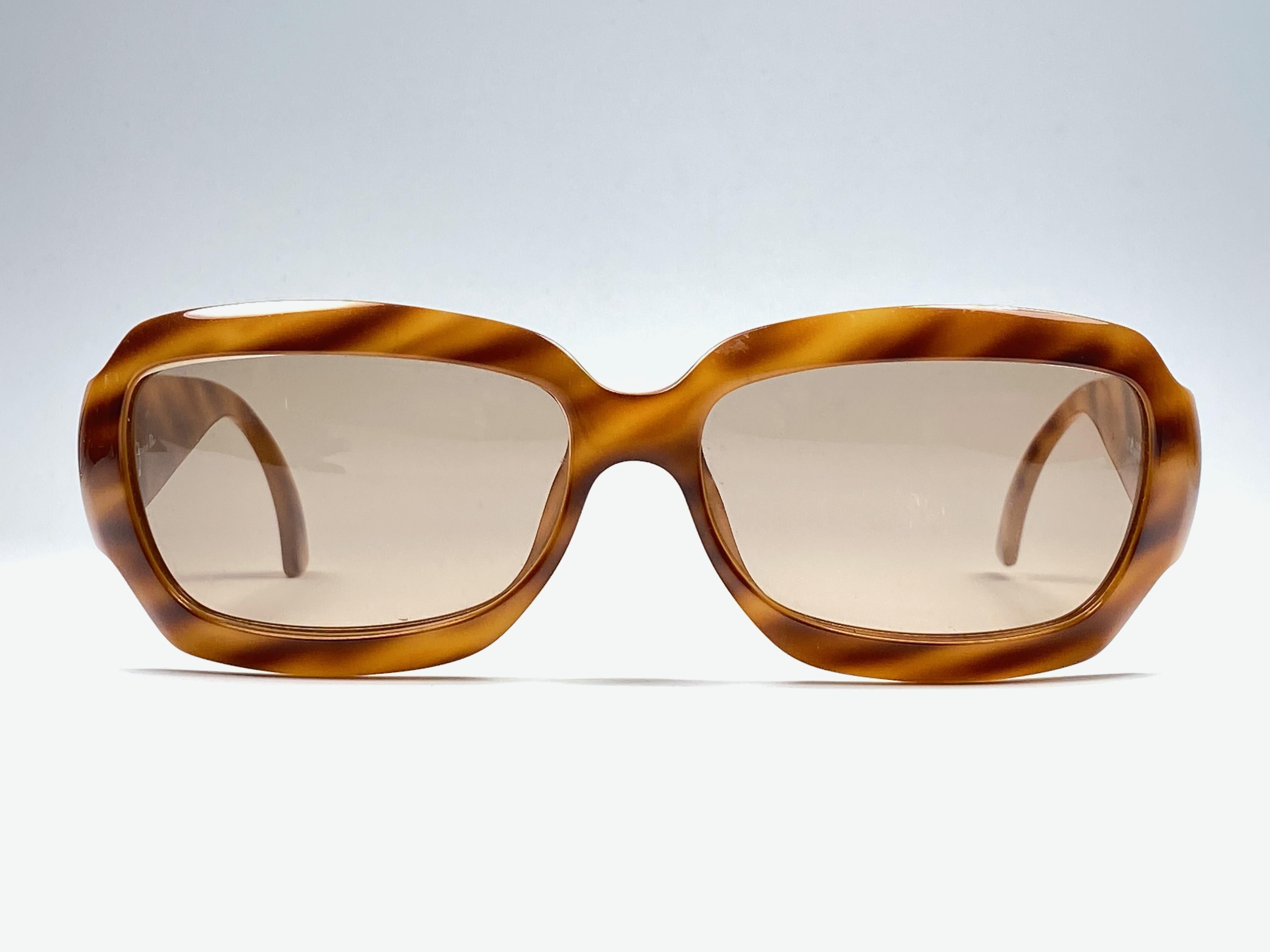 New vintage Christian Dior amber & gold sunglasses. .

Spotless brown lenses.
New, never worn or displayed this item may show light sign of wear due to storage.

Made in Austria

MEASUREMENTS

FRONT : 14 CMS

LENS HEIGHT : 3.5 CMS

LENS WIDTH : 6
