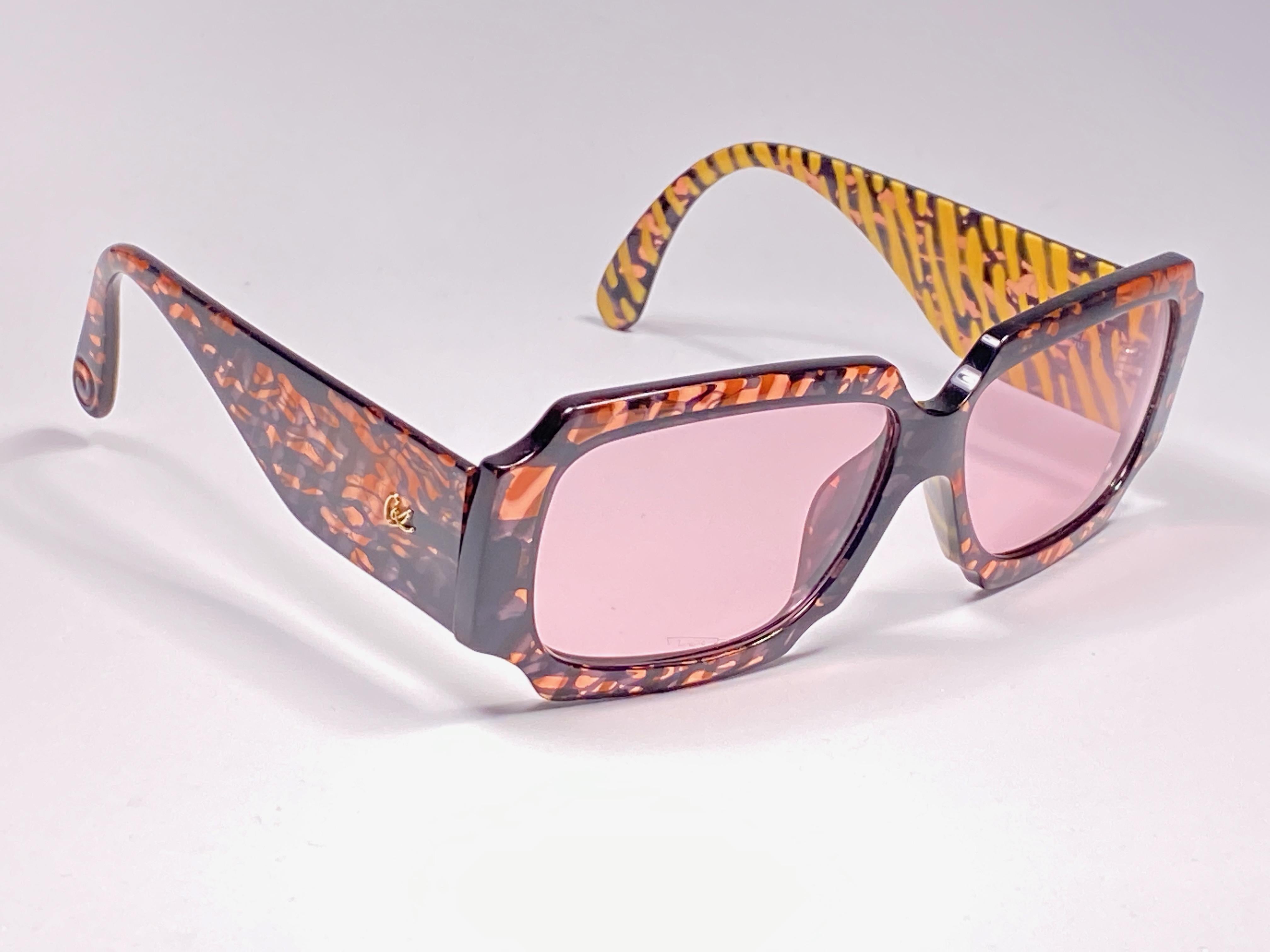 Rare pair of New vintage Christian Lacroix sunglasses.   


Oversized frame holding a pair of spotless light rose lenses. 

New, never worn or displayed. 

Made in France.

MEASUREMENTS :



FRONT : 14 CMS

LENS HEIGHT : 4 CMS

LENS WIDTH : 5.5 CMS