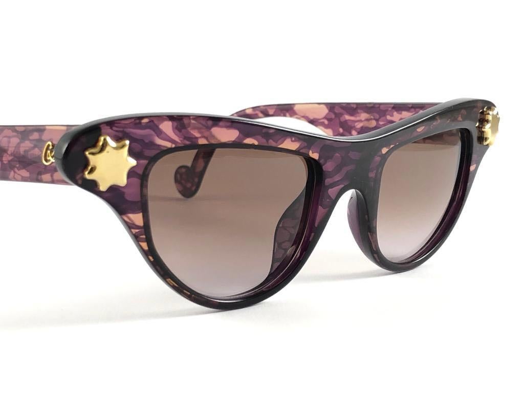 Rare pair of New vintage Christian Lacroix sunglasses. 

Translucent purple with elaborated gold accents, cat eyed shaped frame holding a pair of spotless gradient lenses.

New, never worn or displayed. Made in France.

FRONT : 15 CMS

LENS HEIGHT :