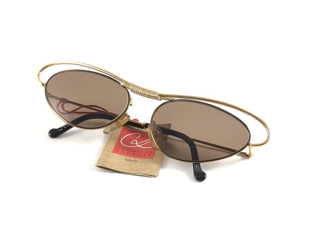 Rare pair of New vintage Christian Lacroix sunglasses. 

Cat eyed shaped frame holding a pair of spotless medium brown lenses.

New, never worn or displayed. Made in France.

FRONT : 15.5 CMS

LENS HEIGHT : 3.5 CMS

LENS WIDTH : 5.8 CMS