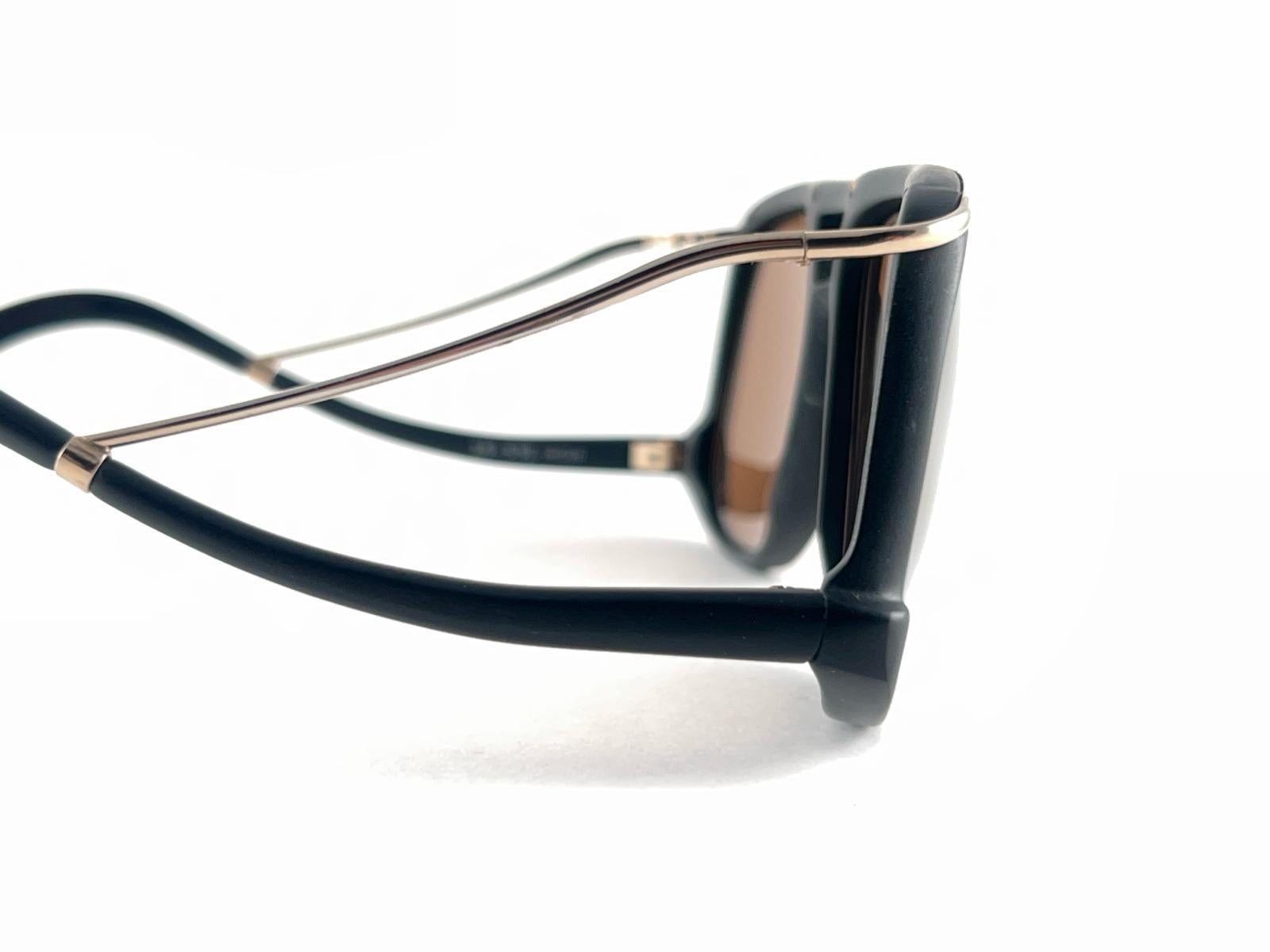 New Vintage Colani Design schwarz matt mit goldenen Akzenten Sonnenbrille. Ausgeschnittener Rahmen mit einem Paar goldener Spiegelgläser.

Nie getragen oder ausgestellt. Dieser Artikel kann aufgrund der fast 40-jährigen Lagerung leichte