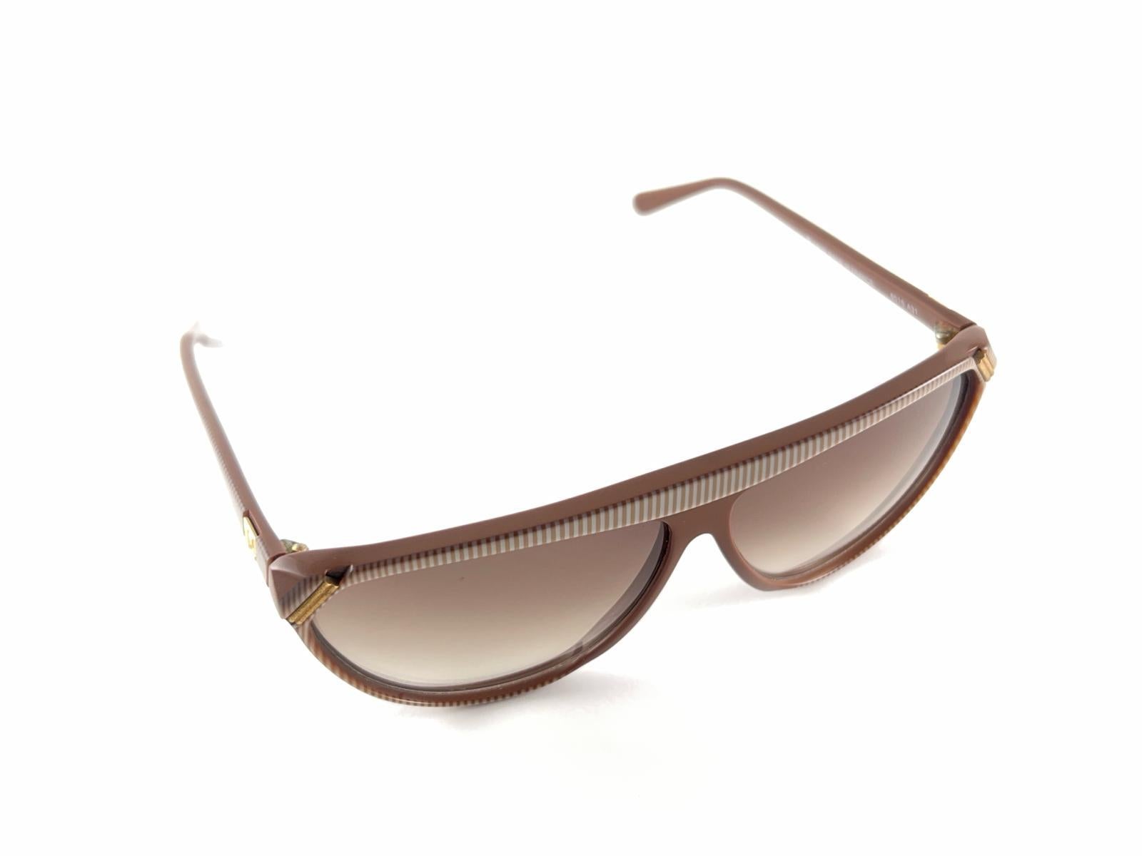 New Vintage Courreges 8516 Moka & Gold Accents Frame Holding A  Pair Of Medium Translucent Brown Lenses Handmade In France 1980’S 
Genius Designer Andre Courreges Signed This Beautiful Pair Of 1980’S Sunglasses
This Item May Show Minor Sign Of Wear