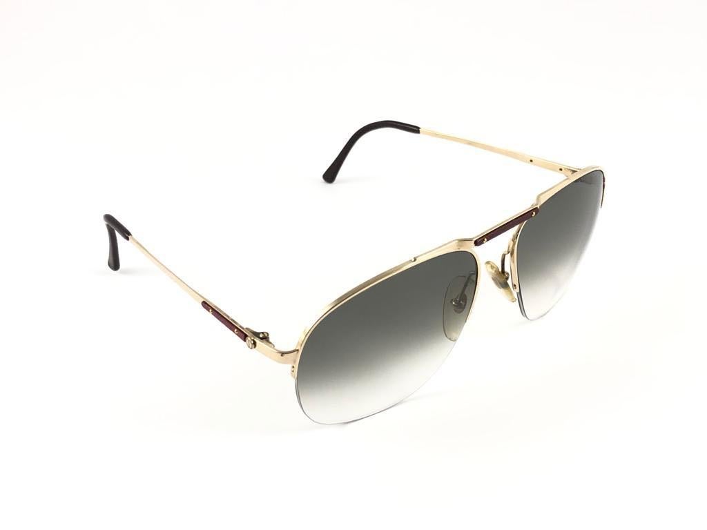 
Neu 1980 Dunhill gold mit Echtholzbesatz halbe Rahmen Sonnenbrille mit braun  (UV-Schutz) Linsen. 
Sie sind wie ein Paar Juwelen auf der Nase.
Schönes Design und ein echtes Zeichen der Zeit. 
Original Dunhill Etui.
Dieses Stück kann aufgrund der