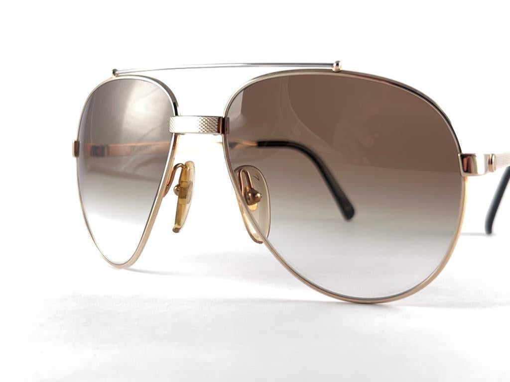 
New 1980 Dunhill 6023 40 Gold Aviator Style Sunglasses. Lentilles dégradées. 
C'est comme une paire de Jewell sur votre nez.
Un design magnifique et un véritable signe des temps. 
Cette pièce peut présenter des signes mineurs d'usure dus au