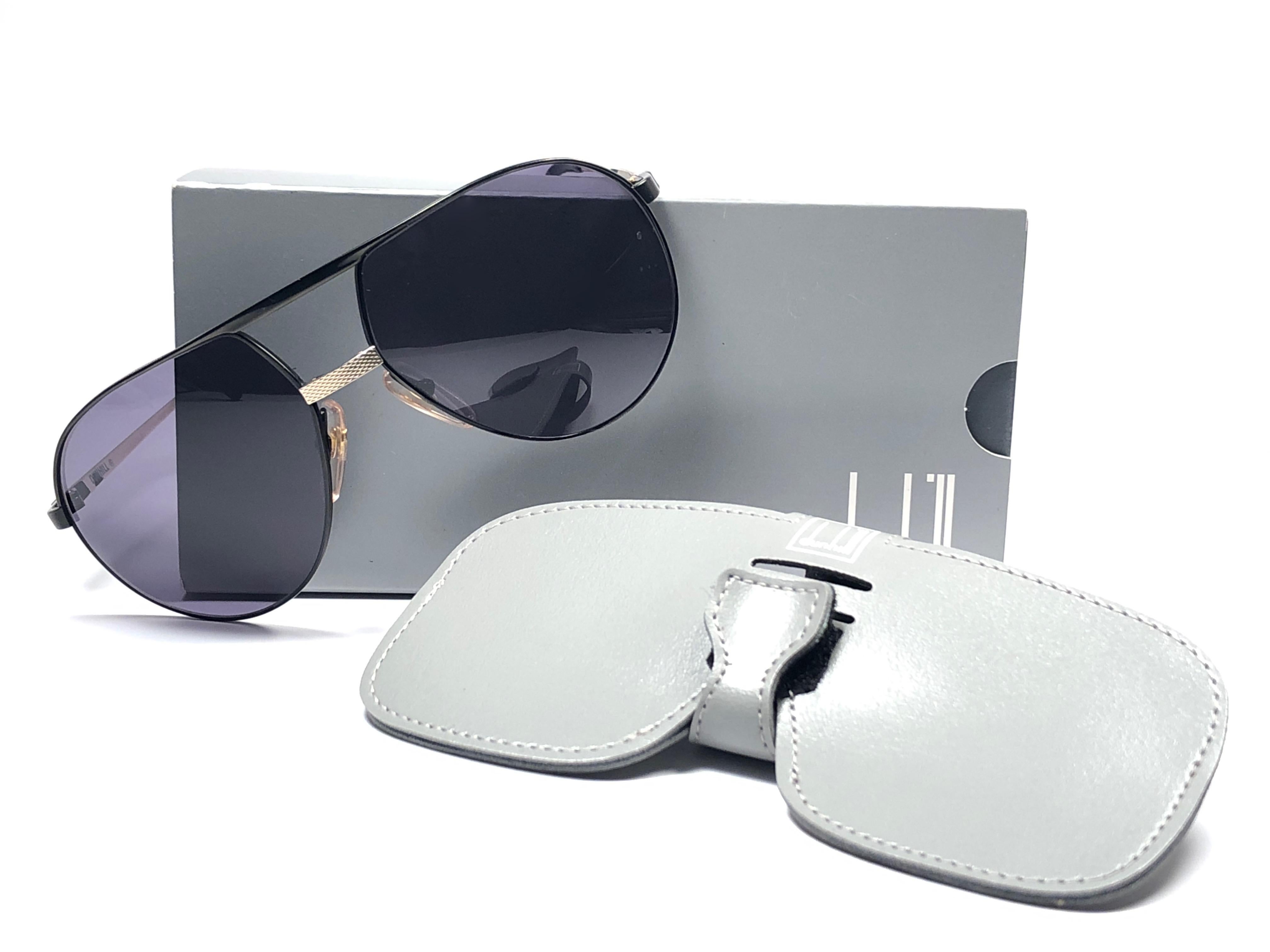 
New 1980 Dunhill schwarzer Pilotenbrille. Graue (UV-Schutz) Gläser. 
Sie sind wie ein Paar Juwelen auf der Nase.
Schönes Design und ein echtes Zeichen der Zeit. 
Original Dunhill Etui.
Dieses Stück kann aufgrund der Lagerung leichte Gebrauchsspuren