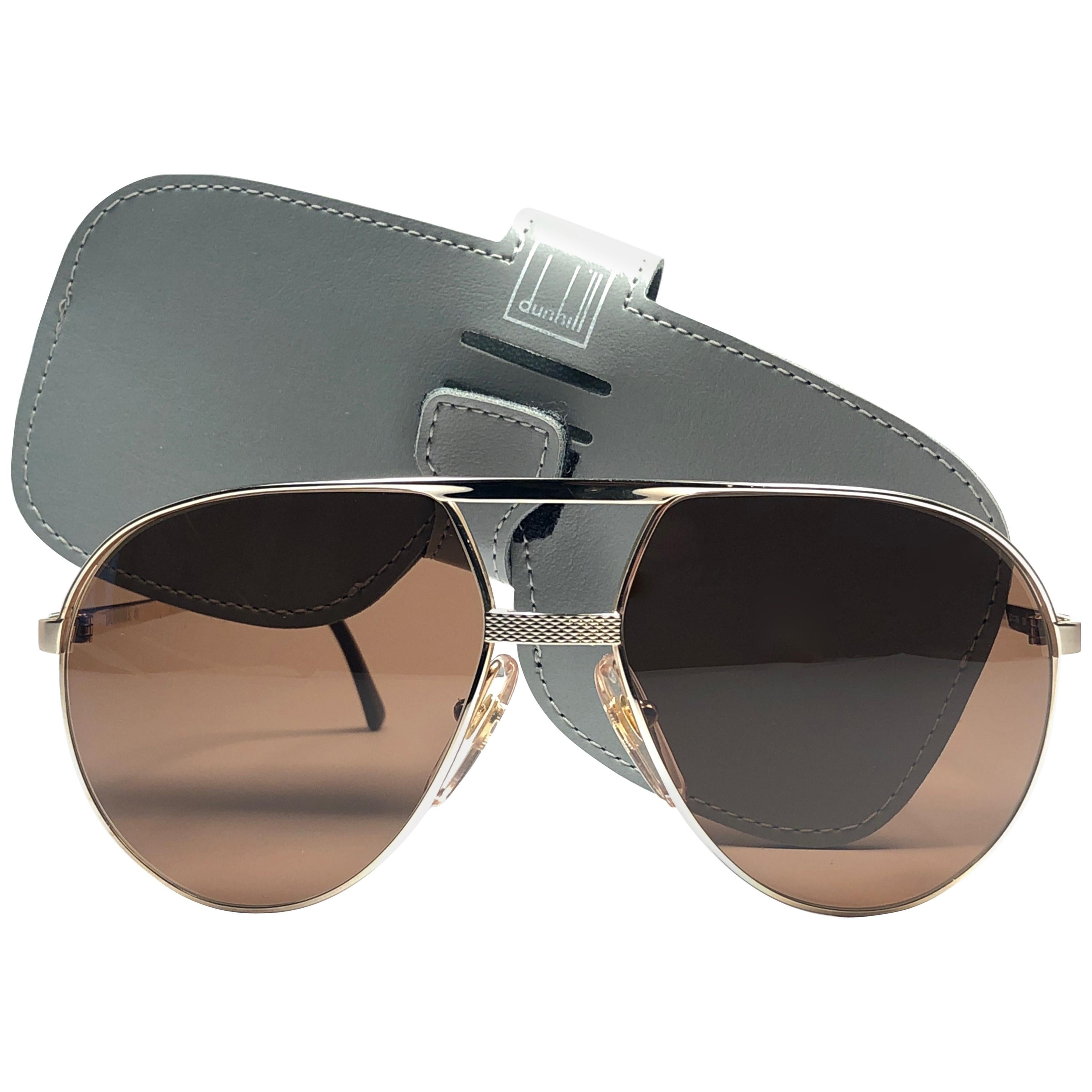 
Neu 1980 Dunhill Aviator Rahmen. Braun (Uv-Schutz) Linsen. 
Sie sind wie ein Paar Juwelen auf der Nase.
Schönes Design und ein echtes Zeichen der Zeit. 

Dieses Stück kann geringfügige Anzeichen von Verschleiß aufgrund der Lagerung zeigen.
1980er