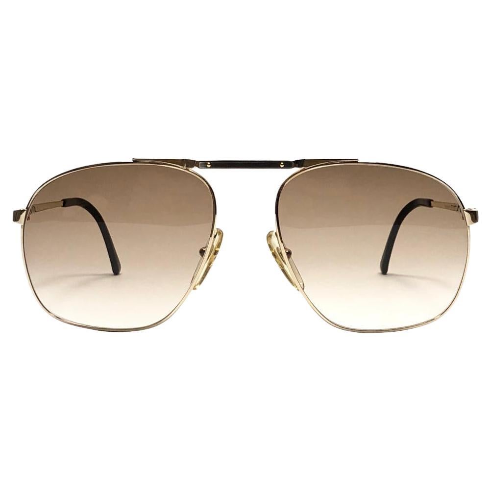
New 1980 Dunhill gold with real wood trims frame sunglasses with brown  (uv protection) lenses. 
These are like a pair of jewels on your nose.
Beautiful design and a real sign of the times. 

This piece may show minor sign of wear due to