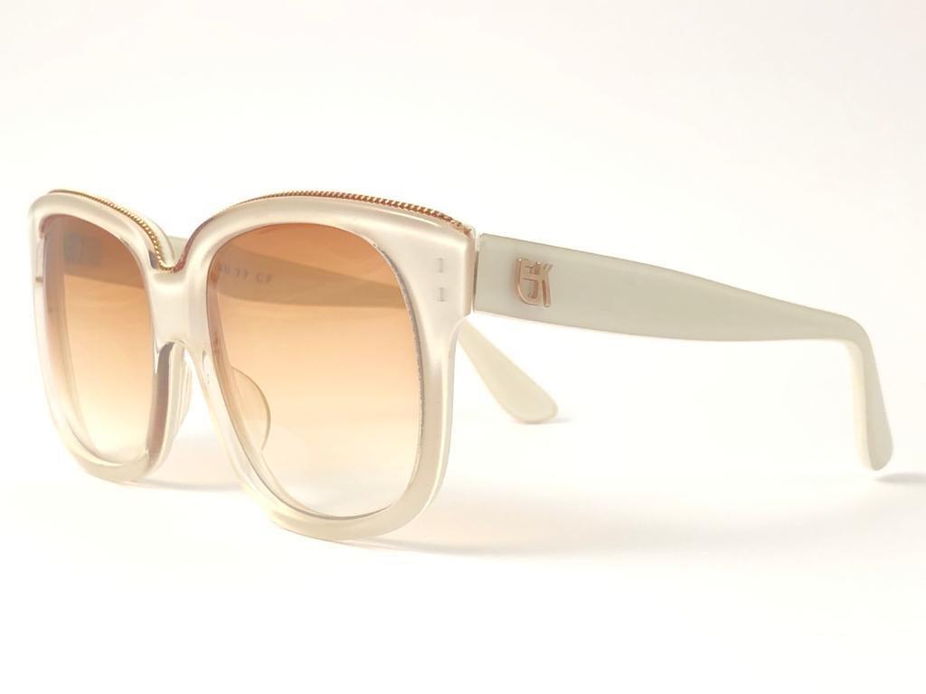 New Vintage Emanuelle Kahn White with gold chain detailed frame with spotless smoke orange gradient lenses.  Made in Paris. 
Produced and design in 1980's.  
New, never worn or displayed. Please consider this item is nearly 40 years old and could