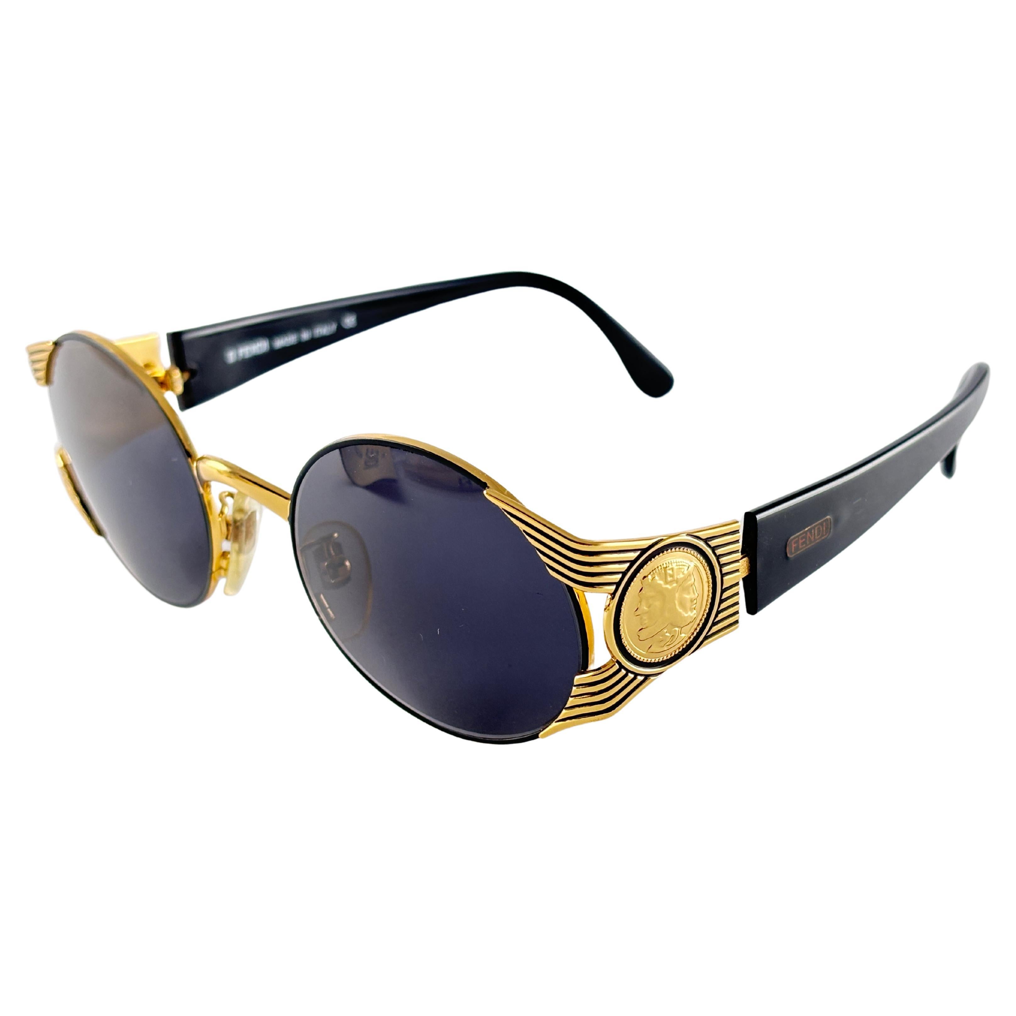 New Fendi black & gold frame with solid grey ( UV protection ) lenses.

Made in Italy.
 
Produced and design in 1990's.

New, never worn or displayed. this  item may show minor sign of wear due to storage.

Measurements :

FRONT : 13.5 CMS

LENS