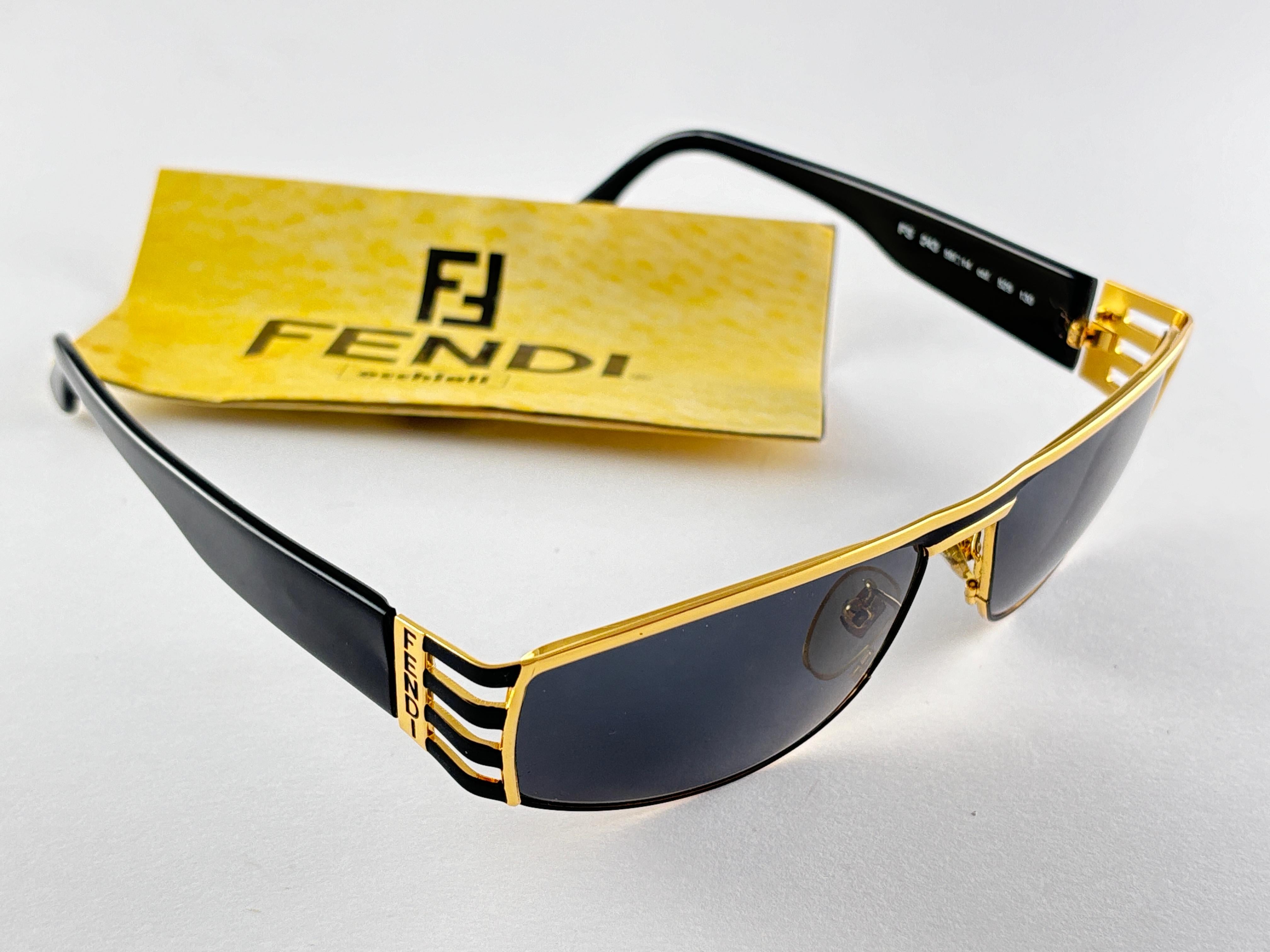 New Fendi gold & black large frame with solid grey ( UV protection ) lenses.

Made in Italy.
 
Produced and design in 1990's.

New, never worn or displayed. this  item may show minor sign of wear due to storage.


FRONT : 14 CMS
LENS HEIGHT : 4.5