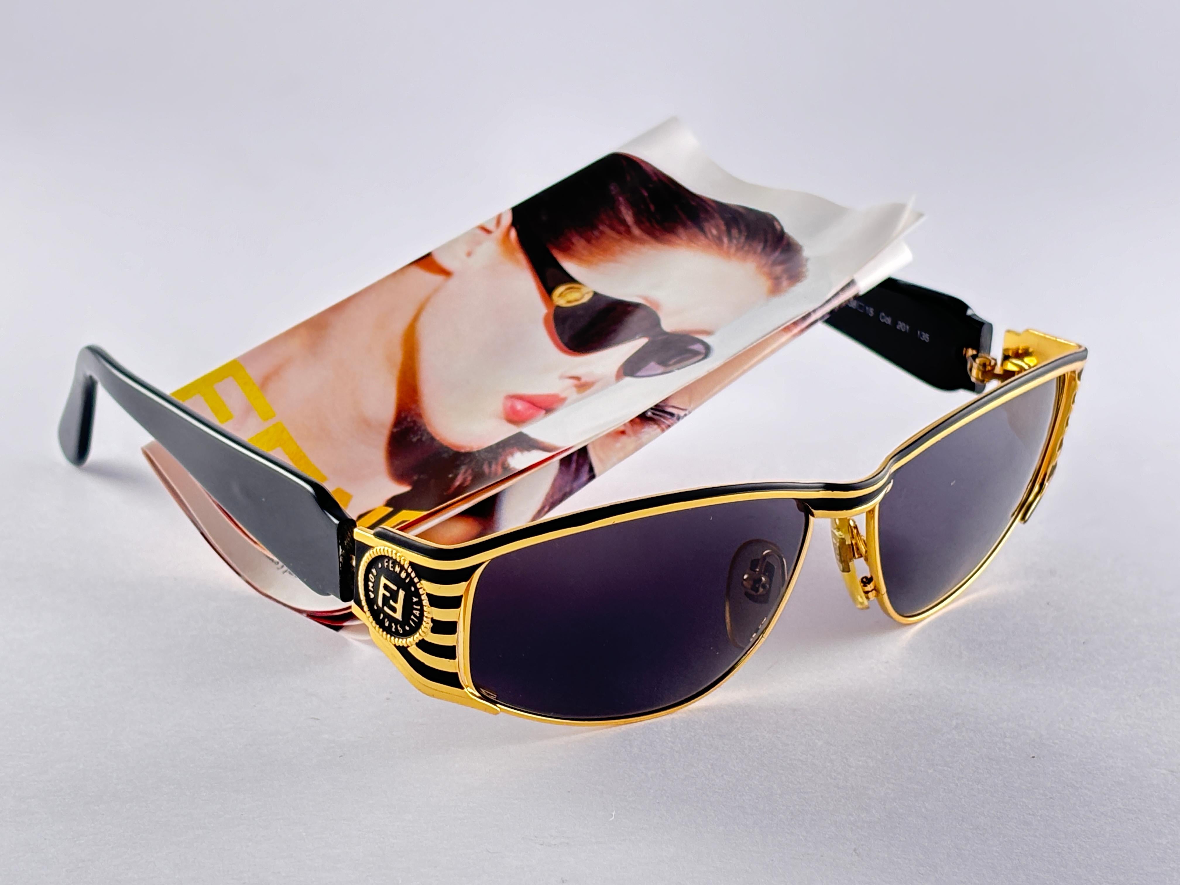 New Fendi gold & black large frame with solid grey ( UV protection ) lenses.

Made in Italy.
 
Produced and design in 1990's.

New, never worn or displayed. this  item may show minor sign of wear due to storage.


FRONT : 14 CMS
LENS HEIGHT : 4.5
