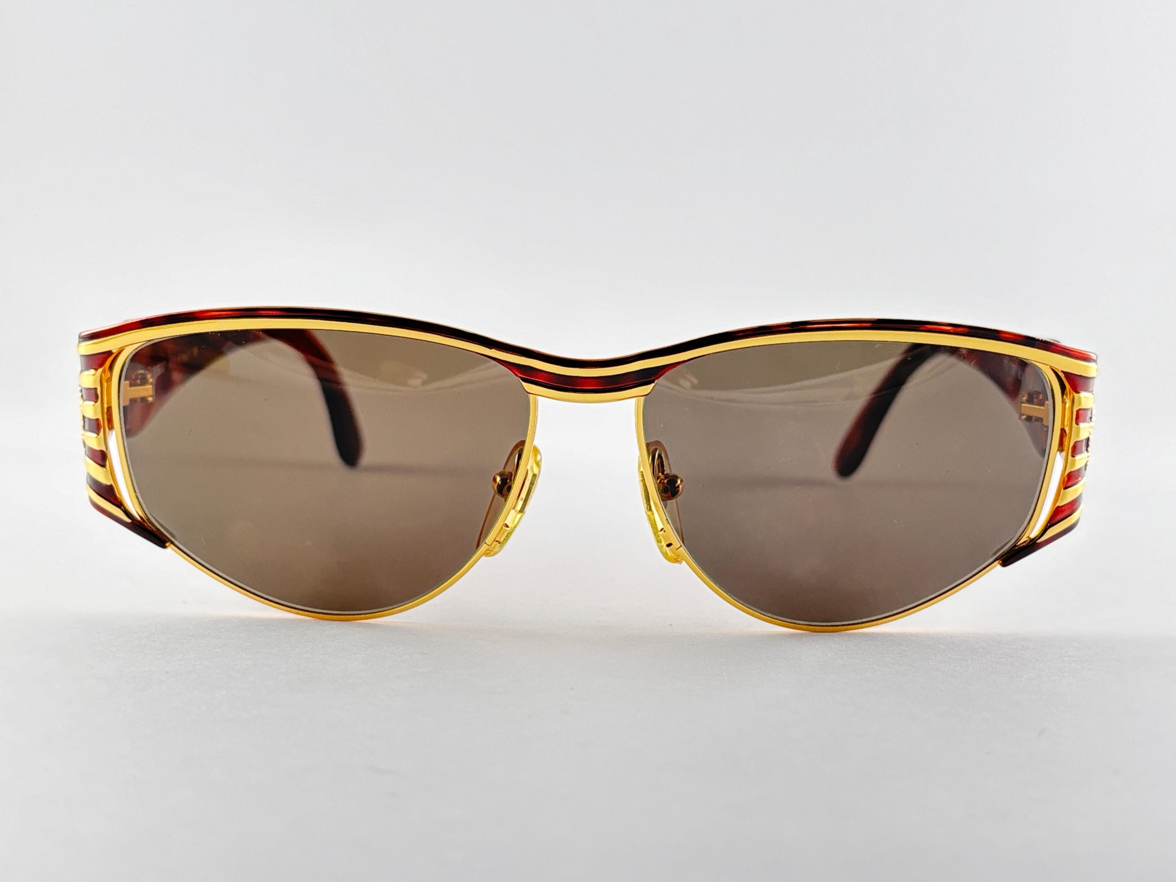 New Fendi gold & tortoise large frame with solid grey ( UV protection ) lenses.

Made in Italy.
 
Produced and design in 1990's.

New, never worn or displayed. this  item may show minor sign of wear due to storage.


Front : 14 cms
Lens Height : 4.5