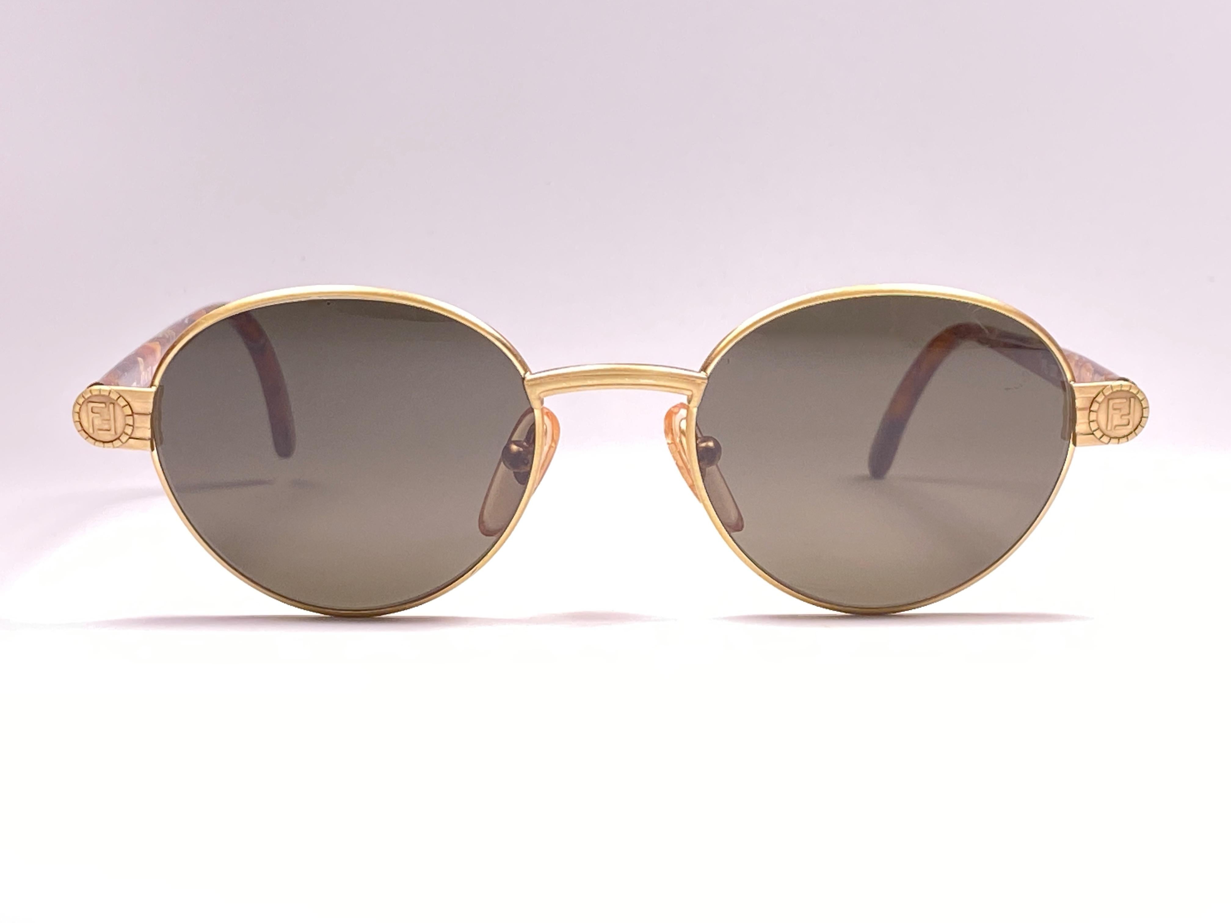 New Fendi gold matte oval frame with solid grey ( UV protection ) lenses.

Made in Italy.
 
Produced and design in 1990's.

New, never worn or displayed. this  item may show minor sign of wear due to storage.