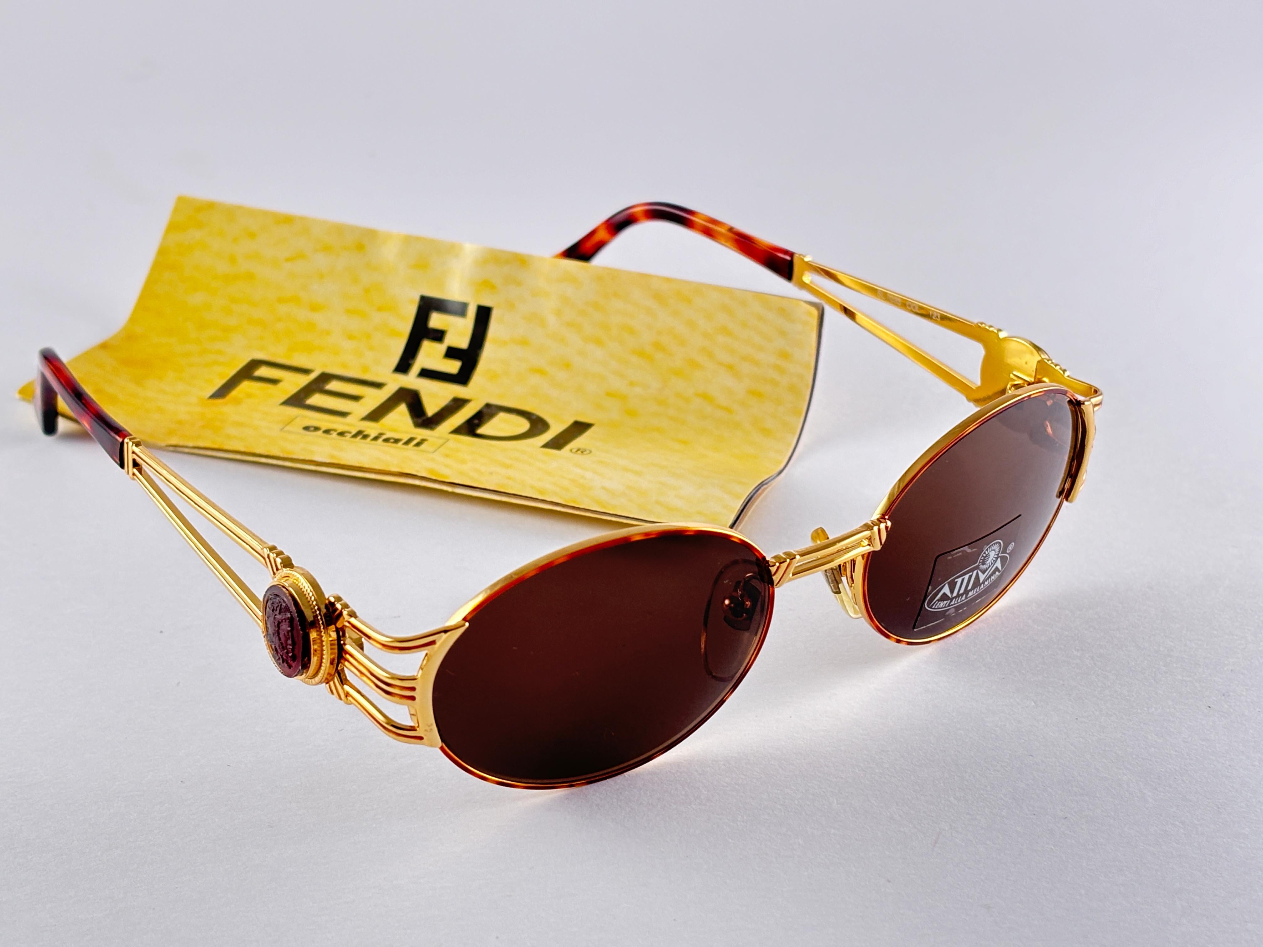 New Fendi gold & tortoise frame with solid brown ( UV protection ) lenses.

Made in Italy.
 
Produced and design in 1990's.

New, never worn or displayed. this  item may show minor sign of wear due to storage.

Measurements :

FRONT : 13.5 CMS

LENS
