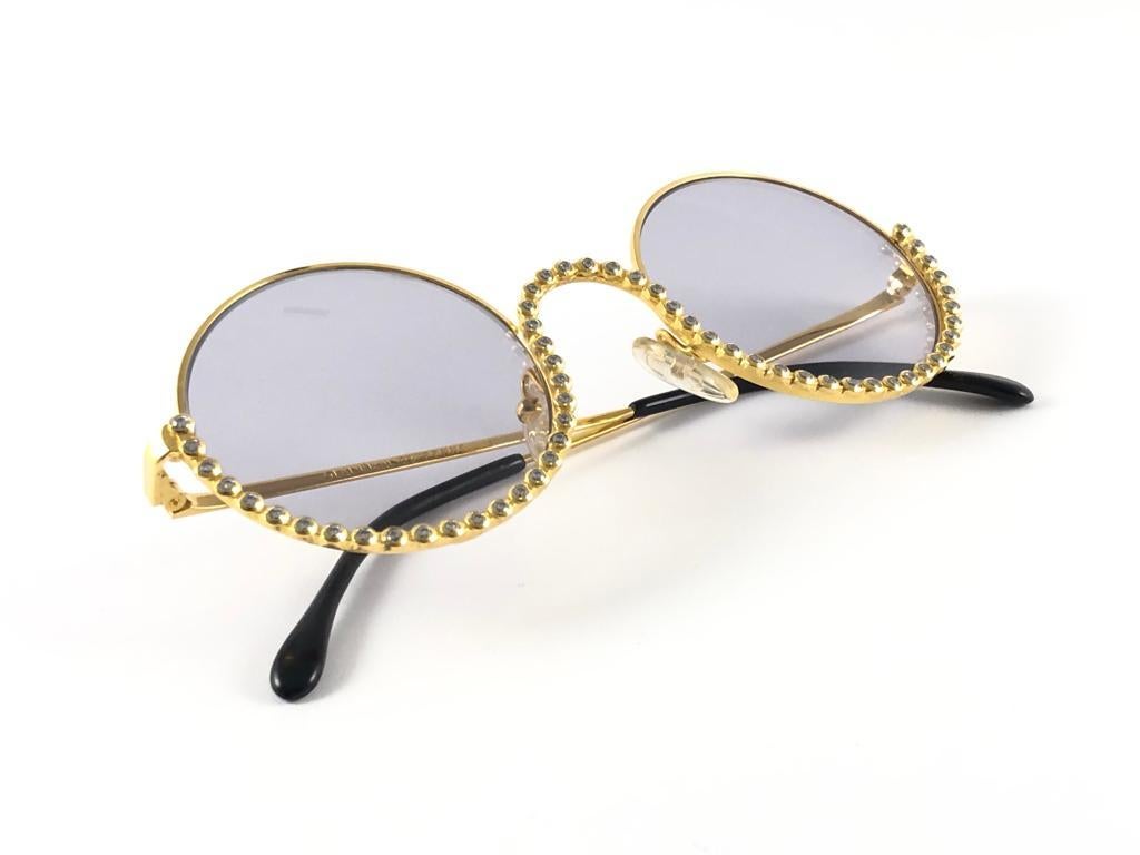 New vintage Gianfranco Ferre gold & strass sunglasses.

Gold & rhinestones details frame holding a pair of spotless grey lenses.   

New, never worn or displayed. 

 Made in Italy.

MEASUREMENTS

FRONT  13 CMS
LENS HEIGHT  4.6 CMS
LENS WIDTH  4.6