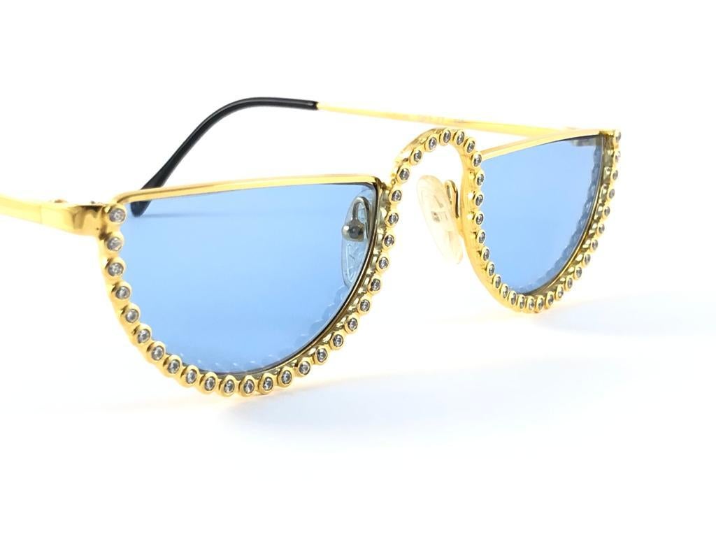 New vintage Gianfranco Ferre gold & strass sunglasses.

Gold & rhinestones details frame holding a pair of spotless grey lenses.   

New, never worn or displayed. 

 Made in Italy.

MEASUREMENTS

FRONT  13 CMS
LENS HEIGHT  2.9 CMS
LENS WIDTH  4.7