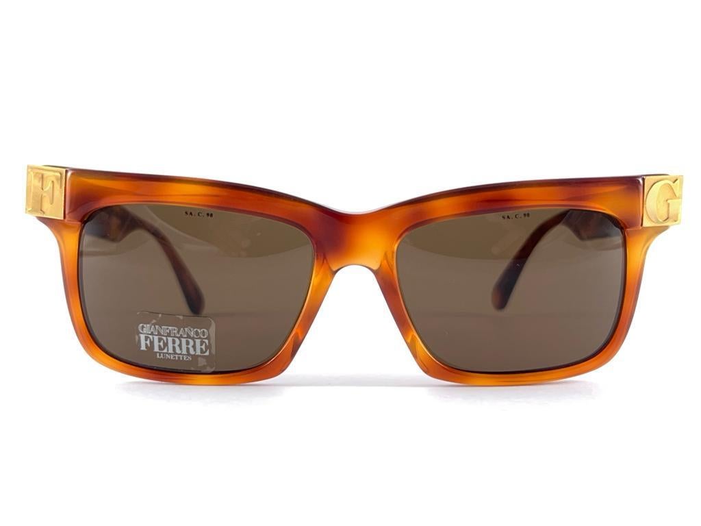 New Vintage Gianfranco Ferre Sunglasses.    
Gold And Tortoise Details Frame Holding A Pair Of Spotless Brown Lenses.   
New, Never Worn Or Displayed. 
This Item May Show Minor Sign Of Wear Due To Storage


 Made In Italy



Front                   