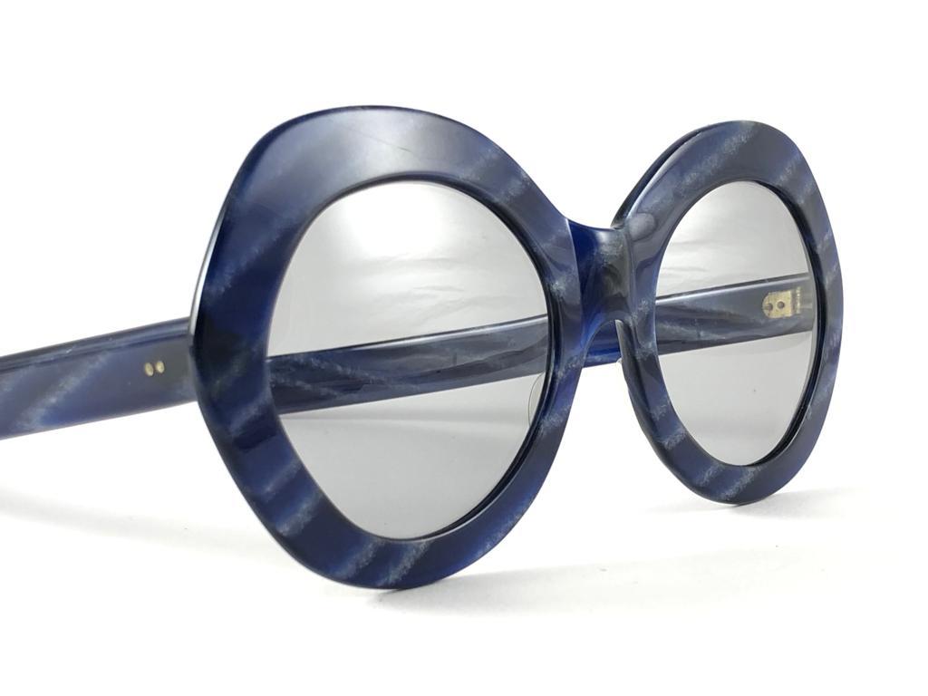 Vintage Givenchy oversized marbled blue frame. Spotless light blue lenses.

Made in France.

Produced and design in 1970's.

This item show minor sign of wear due to storage.

MEASUREMENTS :


FRONT : 16 CMS

LENS HEIGHT : 5 CMS

LENS WIDTH : 5.5