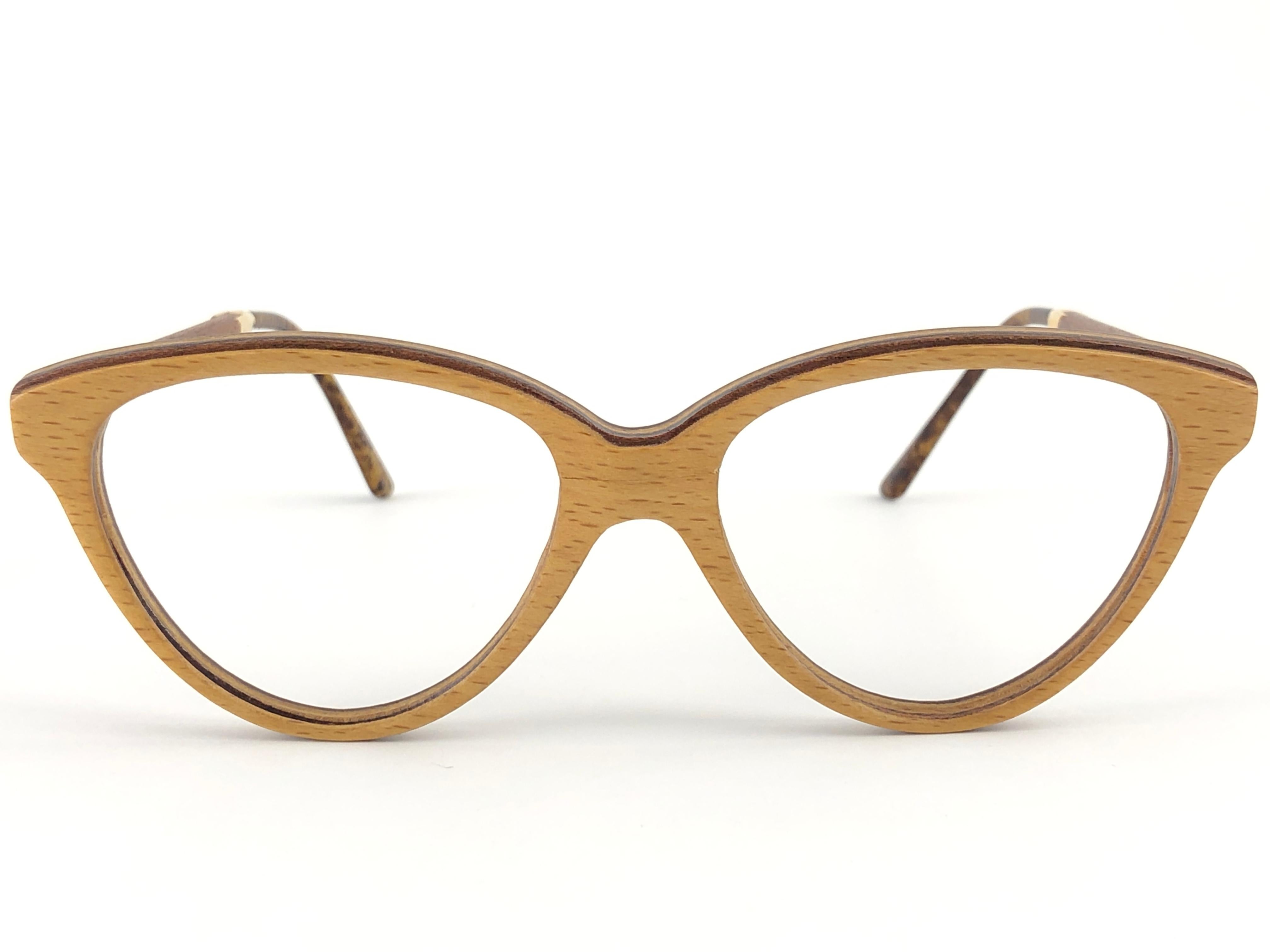 New Vintage Gold & Wood Paris genuine wood frame ready for prescription or reading lenses.
New, never worn or displayed. This pair may have minor sign of wear due to storage. 

Made in France.

Measurements

Frame Width  14 cms
Lens Height  4.2