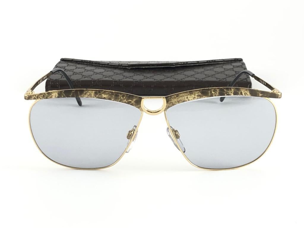 Neu Vintage Gucci schlank  marmorierter und goldener Rahmen mit hellgrauen Gläsern. 
Neu, nie getragen oder ausgestellt. 
Dieser Artikel kann aufgrund der fast 30-jährigen Lagerung leichte Gebrauchsspuren aufweisen. Hergestellt in