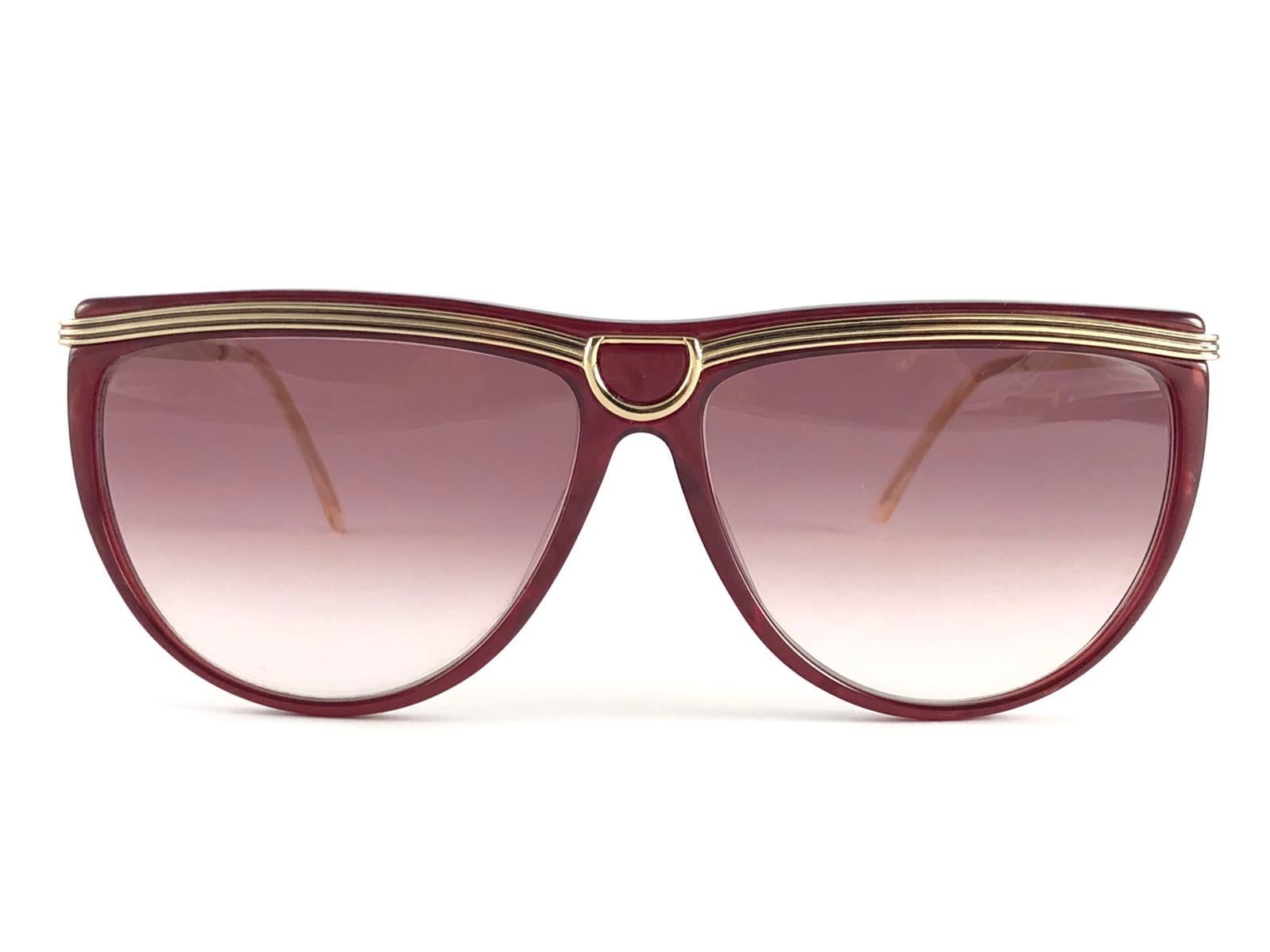 New Vintage Gucci sleek burgundy & gold accents frame with light gradient pink lenses. 

New never worn or displayed. 

This item could show minor sign of wear due to nearly 30 years of storage. Made in Italy.

Front                       13.5  