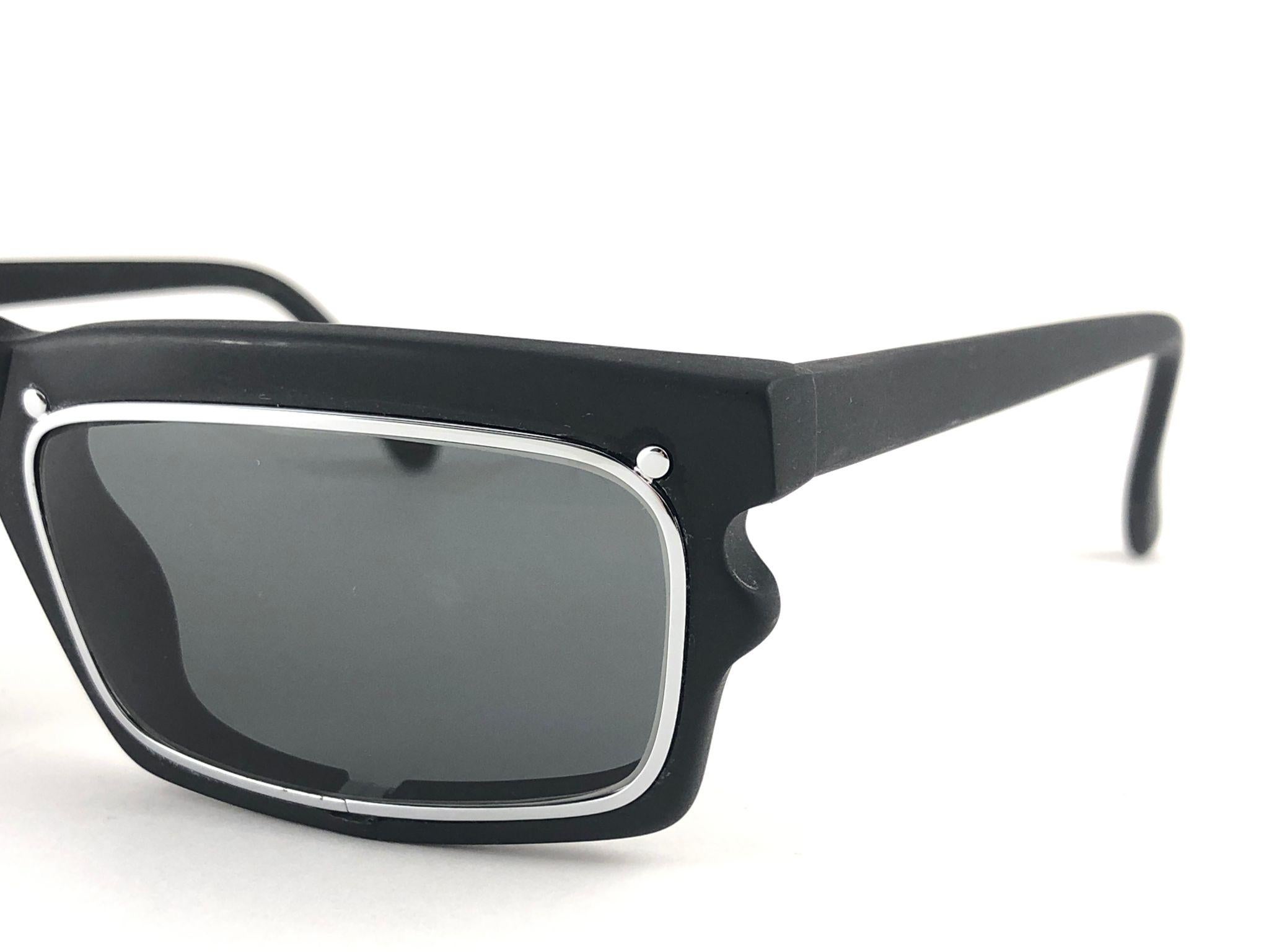 New vintage IDC 767, rectangular Black Mate frame holding pair of grey lenses.  
The very same model worn by Anthony Kiedis from Red Hot Chili Peppers. New, never worn or displayed this pair may have minor sign of wear due to storage. Made in