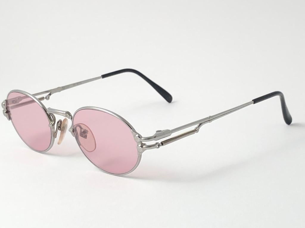New Jean Paul Gaultier 55 4173 Silver Oval frame. 
Light Pink lenses that complete a ready to wear JPG look. 
Amazing design with strong yet intricate details. 
Design and produced in the 1990's. New, never worn or displayed.
A true fashion