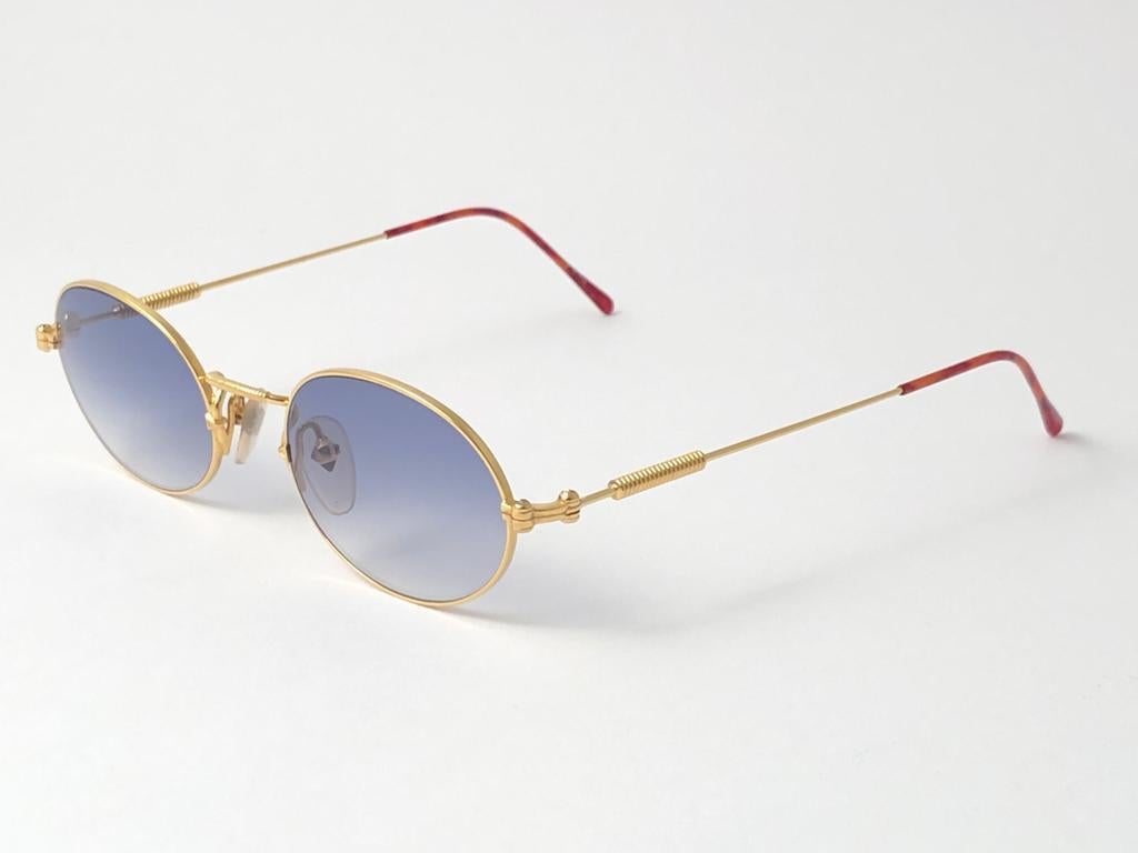 New Jean Paul Gaultier 55 4179 Gold Oval frame. 
Gradient light Blue lenses that complete a ready to wear JPG look. 
Amazing design with strong yet intricate details. 
Design and produced in the 1990's. New, never worn or displayed.
A true fashion