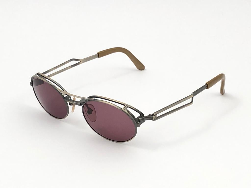 New Vintage Jean Paul Gaultier silver matte frame with sides accents frames.

Design and produced in the 1900's a timeless and iconic piece.

A true fashion statement.

FRONT : 13.5 CMS

LENS HEIGHT : 3.6 CMS

LENS WIDTH : 4.8 CMS

TEMPLES : 12.5