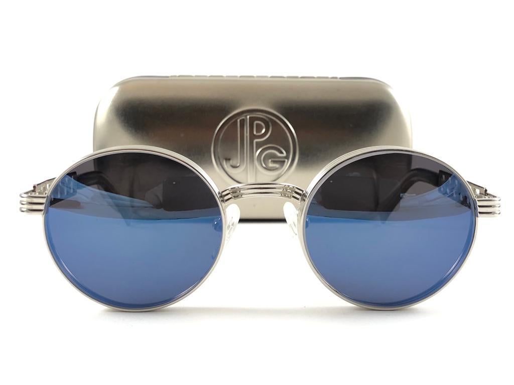 New Vintage Jean Paul Gaultier 56 0173 Silber Details Rahmen. 
Blaue verspiegelte Gläser, die einen tragbaren JPG-Look vervollständigen. Die Gläser haben leichte Gebrauchsspuren.

Erstaunliches Design mit starken, aber raffinierten Details.
Design
