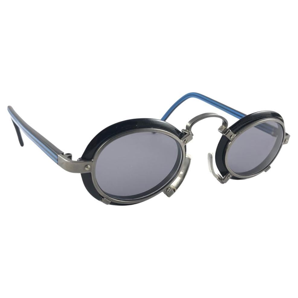 New Vintage Jean Paul Gaultier black and silver metal accents frames. The very same model worn by Miles Davis.

Design and produced in the 1900's a timeless and iconic piece.

A true fashion statement.

FRONT : 13 CMS


LENS HEIGHT : 3.3 CMS


LENS