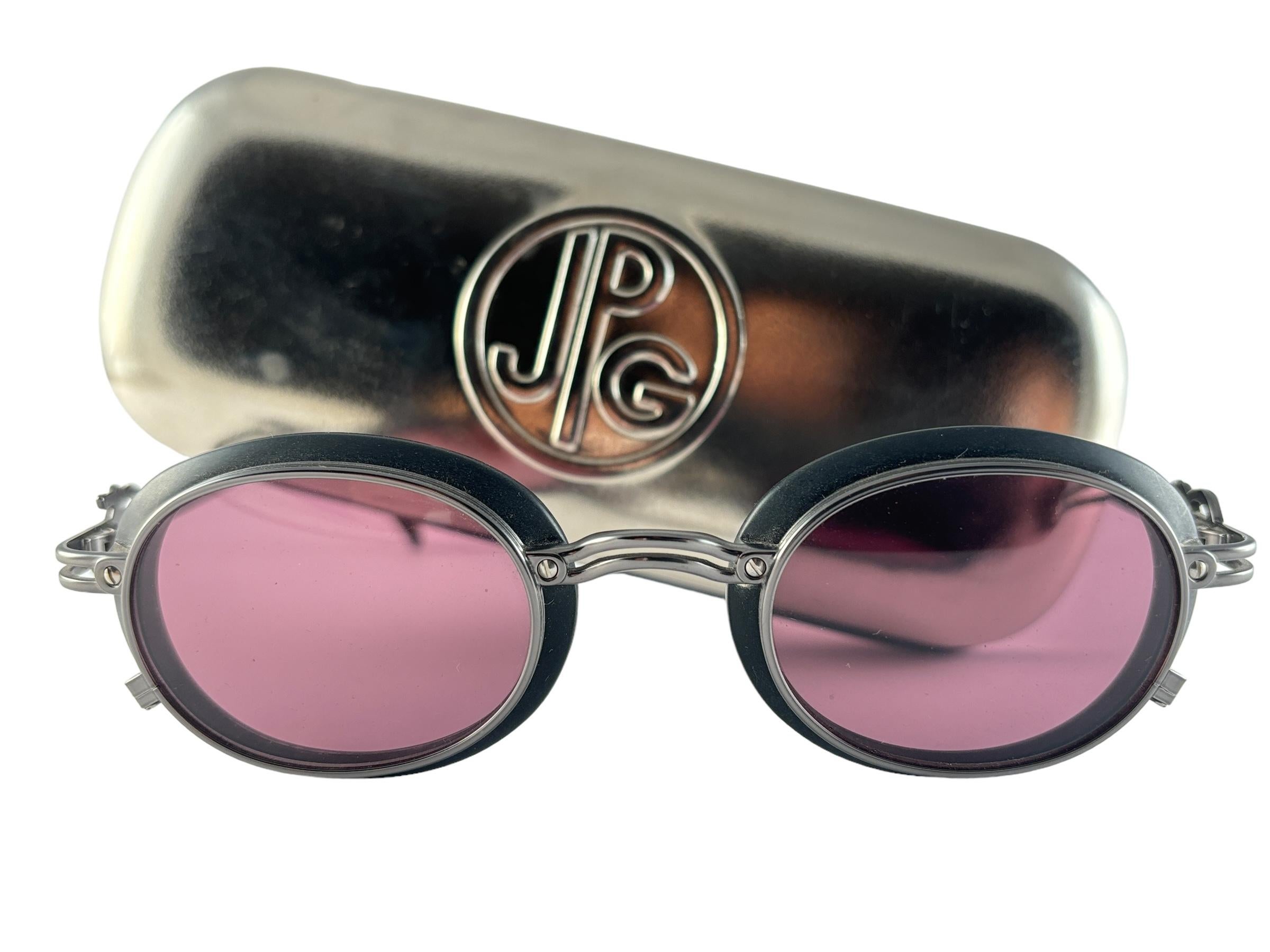 New Jean Paul Gaultier 58 52 01 Oval frame. 
Dark purple lenses that complete a ready to wear JPG look. 
Amazing design with strong yet intricate details. The very same model worn by Maddy on season 2 of Euphoria.
Design and produced in the 1990's.