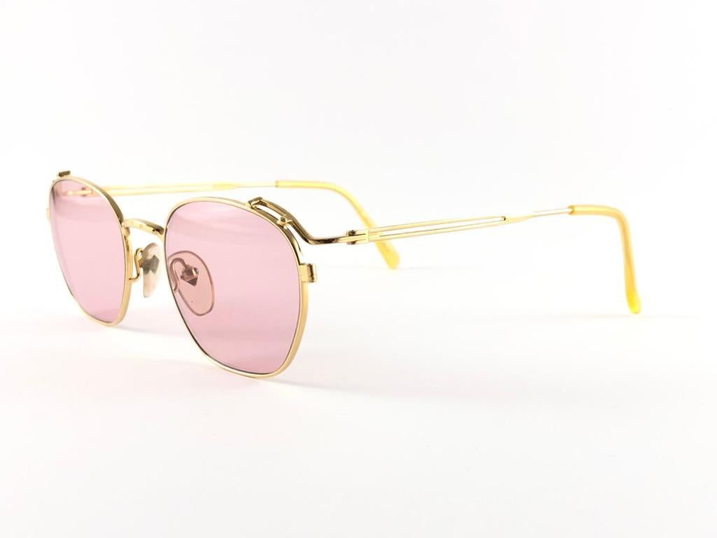 New Jean Paul Gaultier Junior gold frame.

Light pink lenses that complete a ready to wear jpg look. 

Amazing design with strong and elaborated details. made in the 1990's. 

New, never worn or displayed. a true fashion